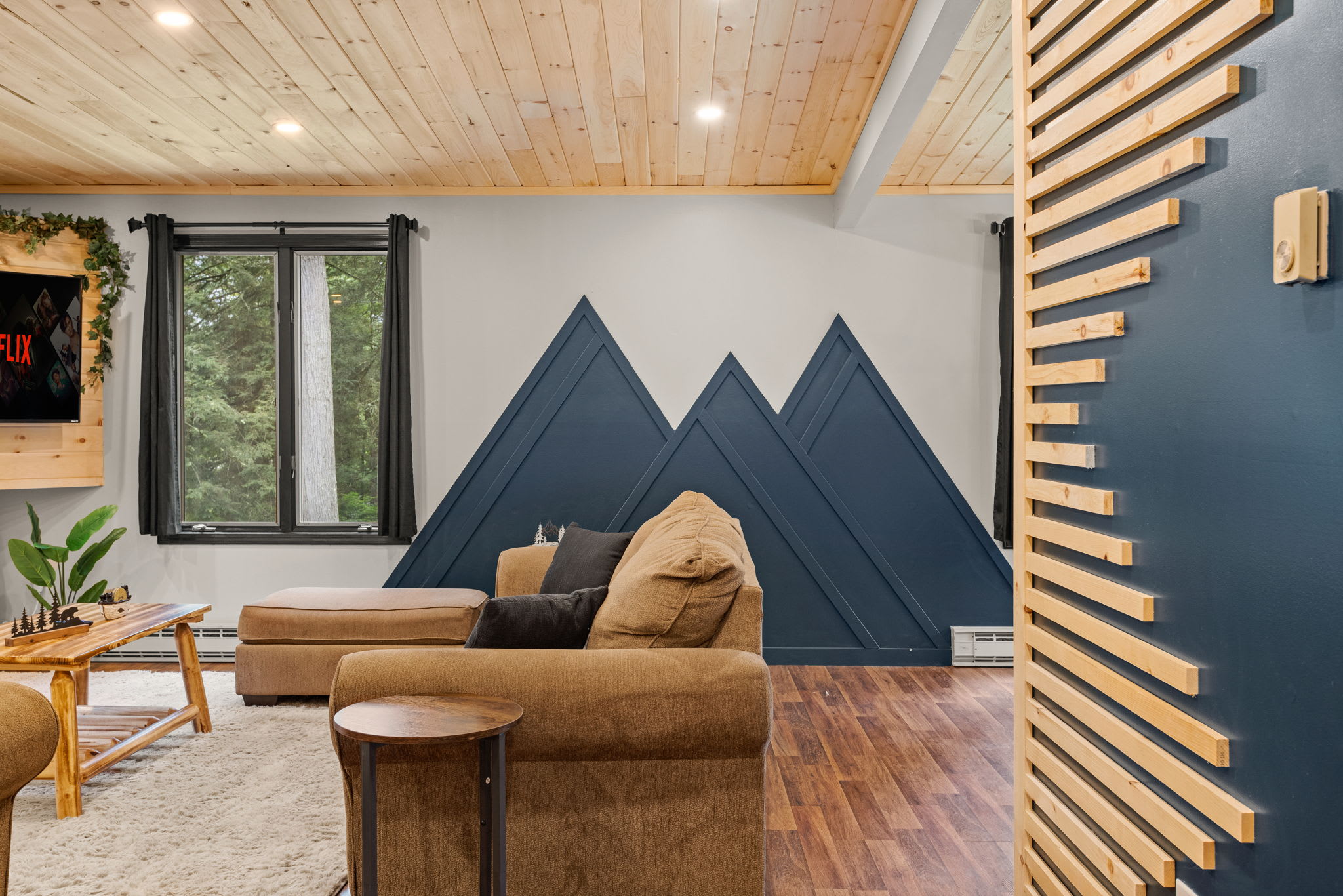 Modern Mountain-Inspired Decor – A stylish living area featuring a unique mountain-themed accent wall, blending rustic charm with contemporary design.