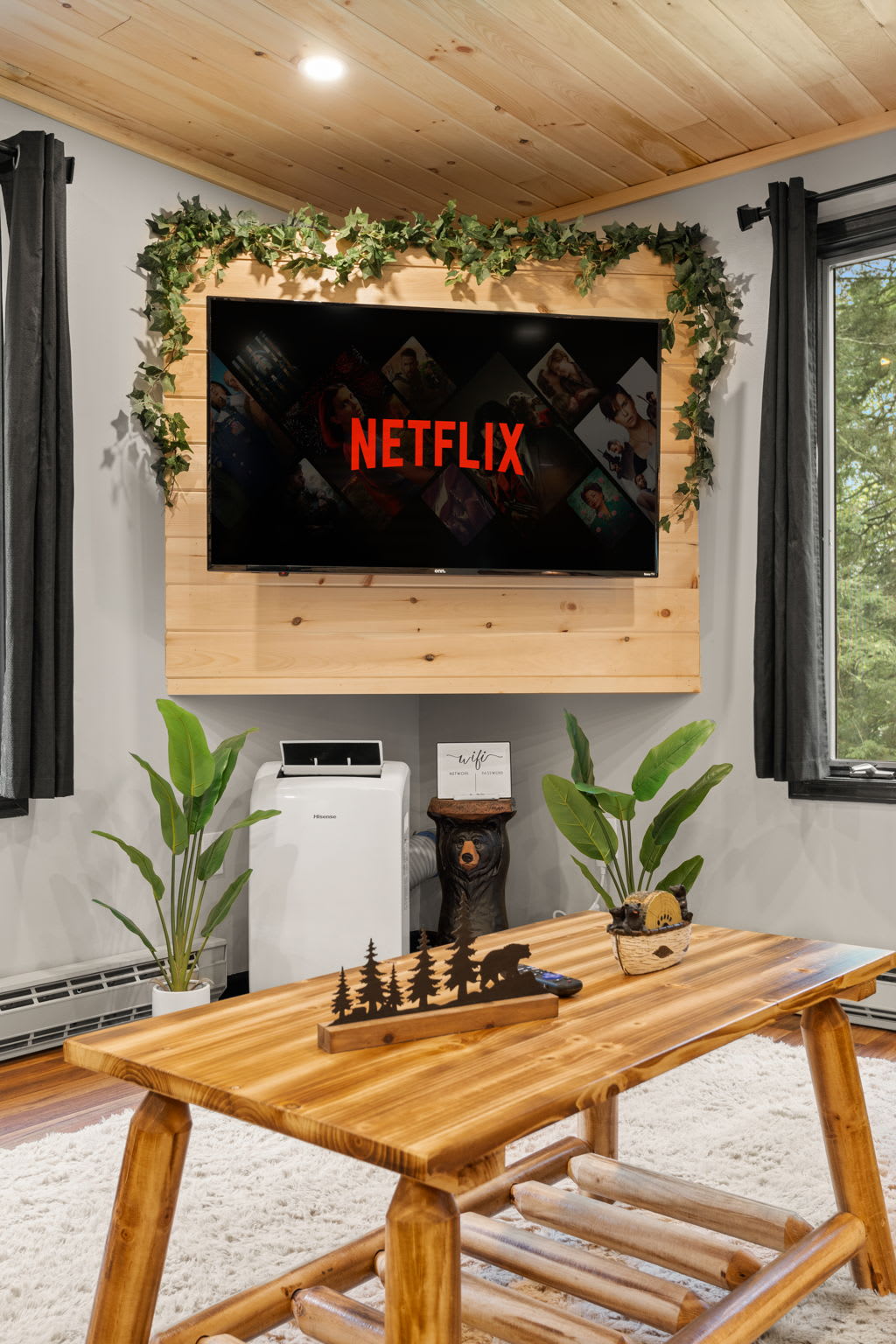 Entertainment-Ready Living Room – A sleek and stylish space with a Netflix-ready TV, rustic wood decor, and comfortable furnishings for a perfect movie night.