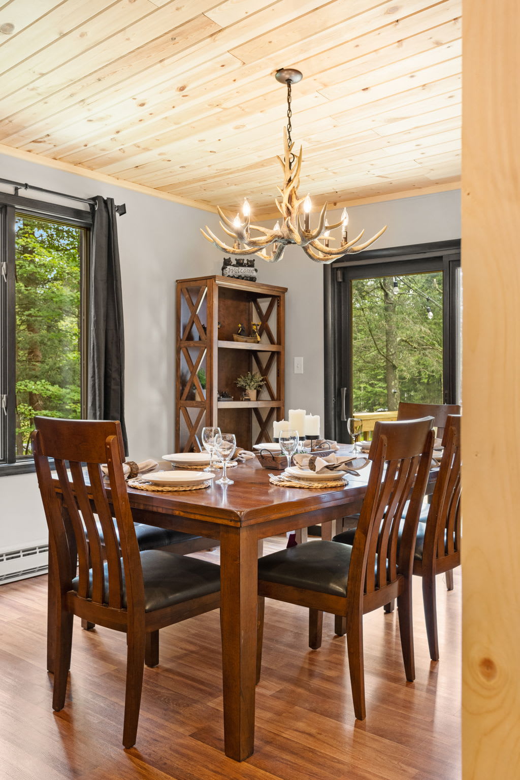 Intimate Dining with a View – A beautifully set dining table positioned near large windows, offering a bright and welcoming space to enjoy meals.