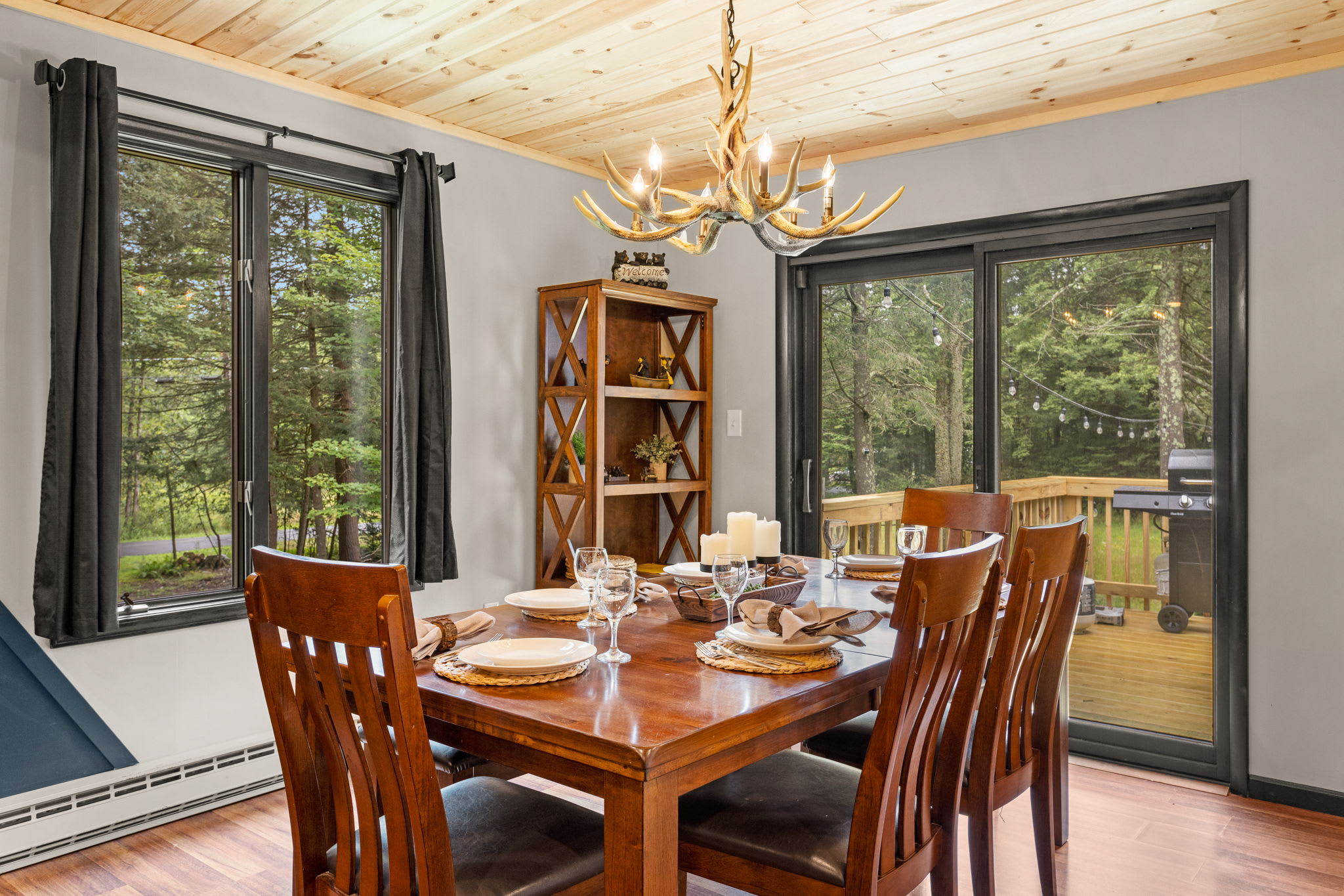 Rustic Charm Meets Modern Elegance – A thoughtfully designed dining room with large windows, stylish decor, and a seamless transition to the outdoor deck.