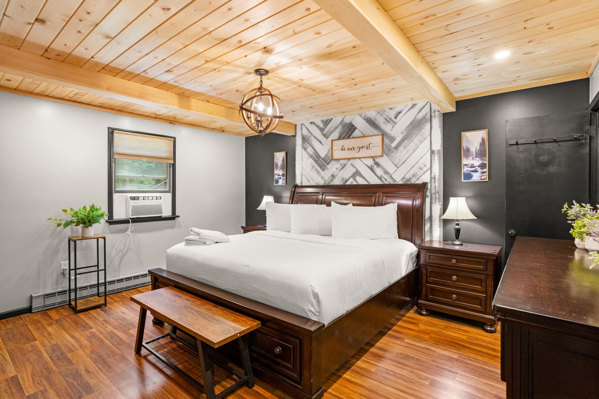 Elegant & Cozy Master Bedroom – A beautifully designed bedroom featuring a wooden beamed ceiling, dark accent walls, and a plush king-sized bed for a luxurious retreat.