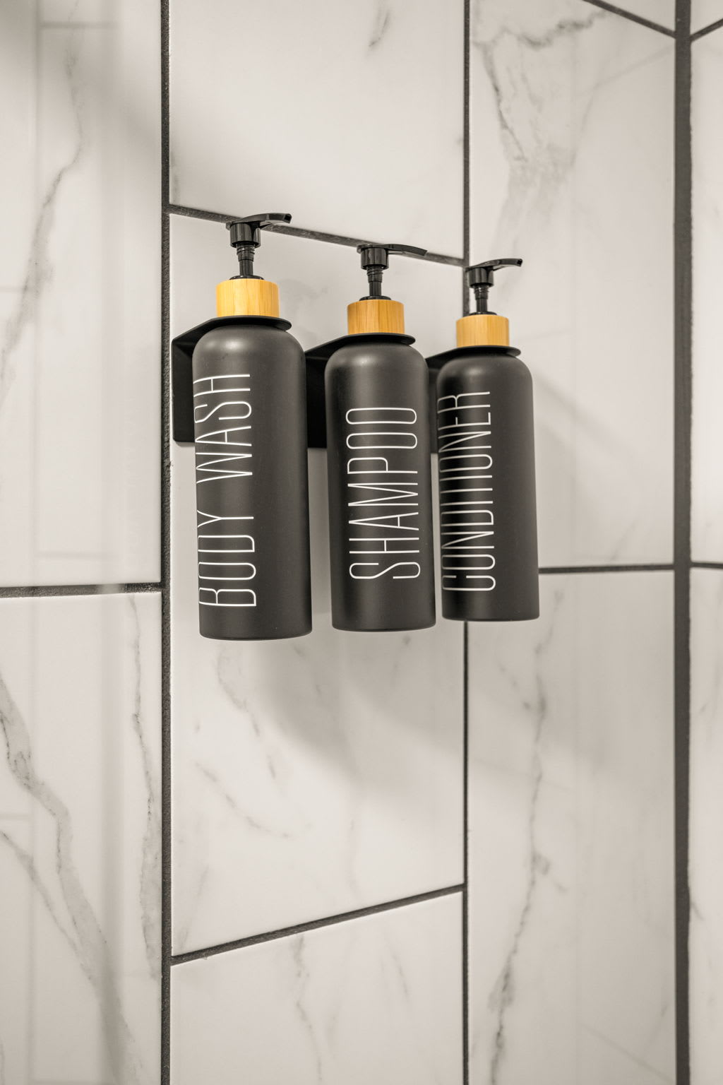 Convenient Shower Essentials – Wall-mounted shampoo, conditioner, and body wash dispensers add a sleek and functional touch to this spa-inspired bathroom.