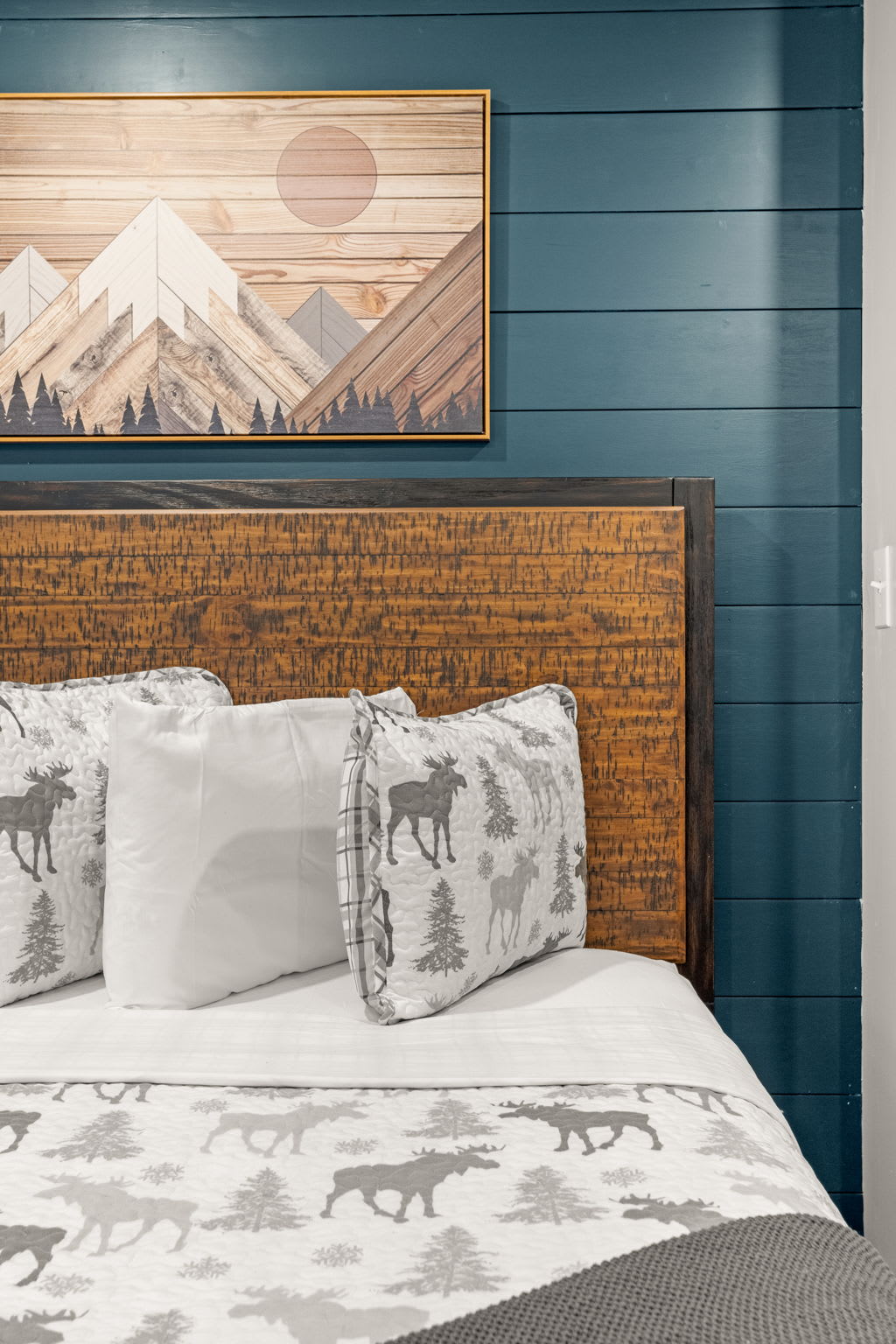 A beautifully designed space with a deep blue accent wall, natural wood elements, and soft bedding for a restful escape.