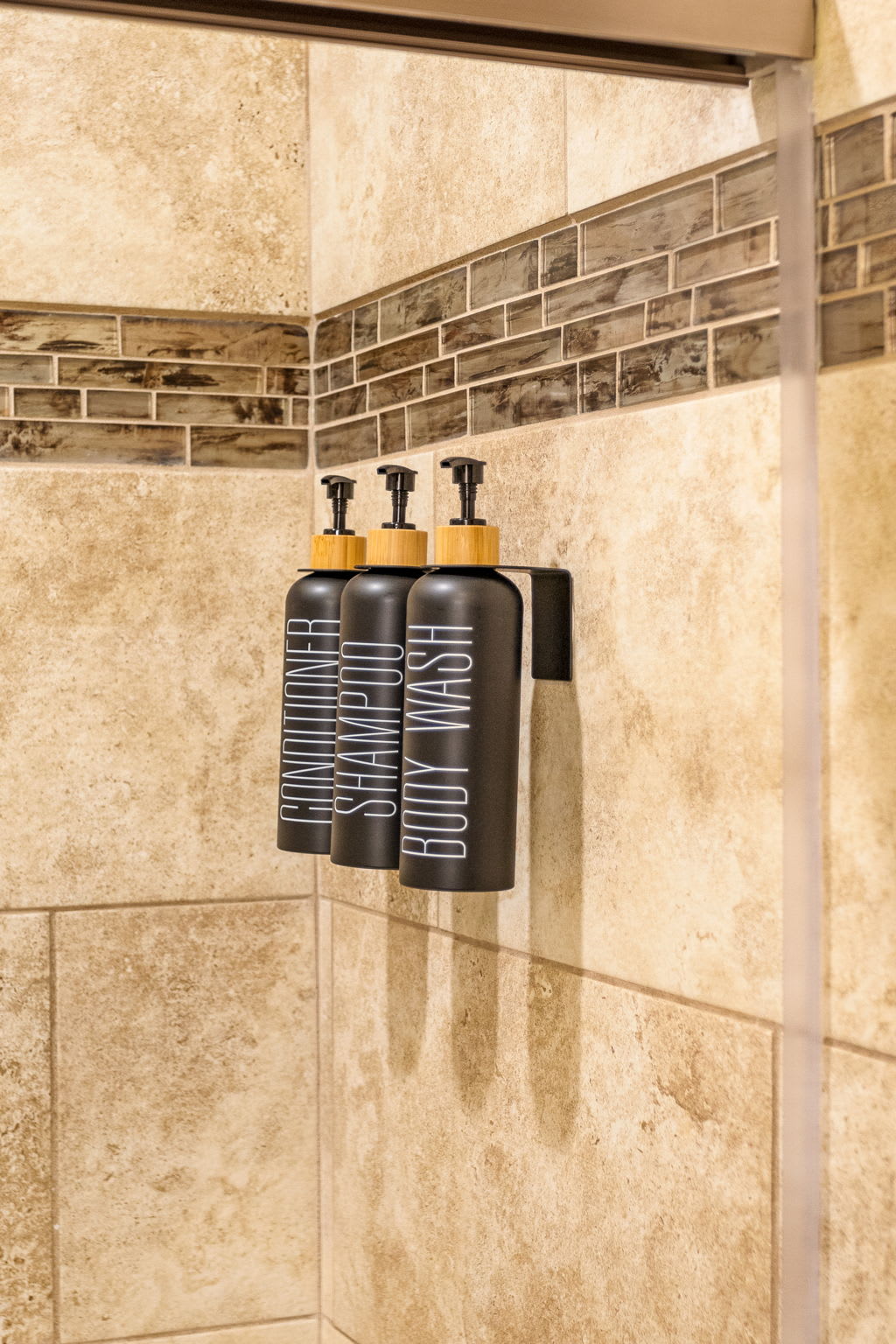 Built-in shampoo and body wash dispensers add a modern, practical touch to this beautifully tiled shower.