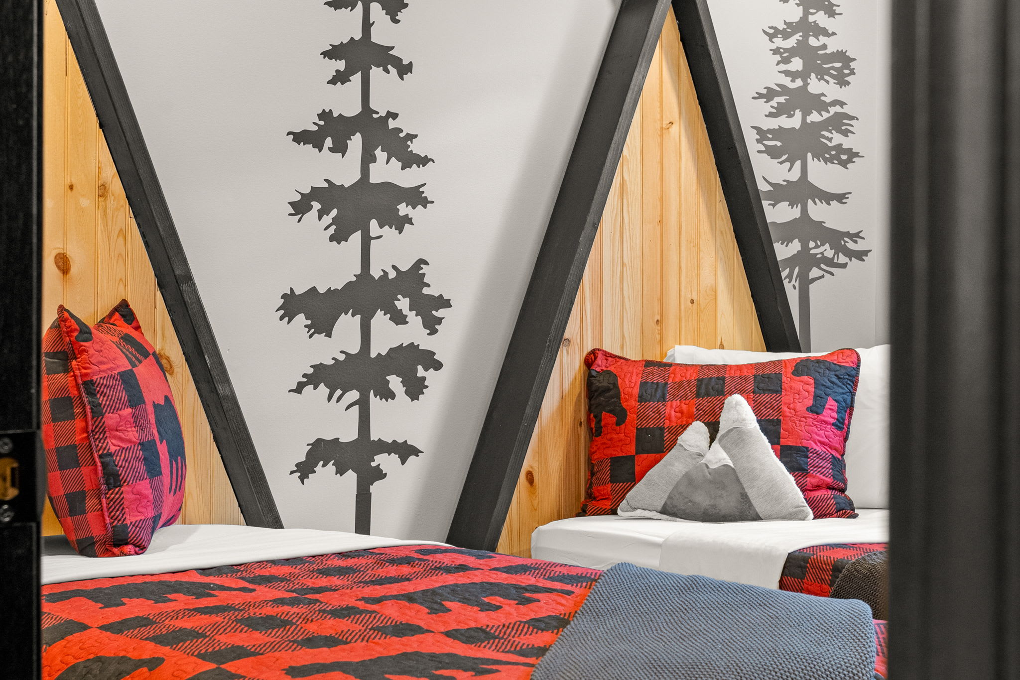 A cozy and stylish sleeping space with bold tree decals, rustic wood accents, and soft lighting for a relaxing atmosphere.