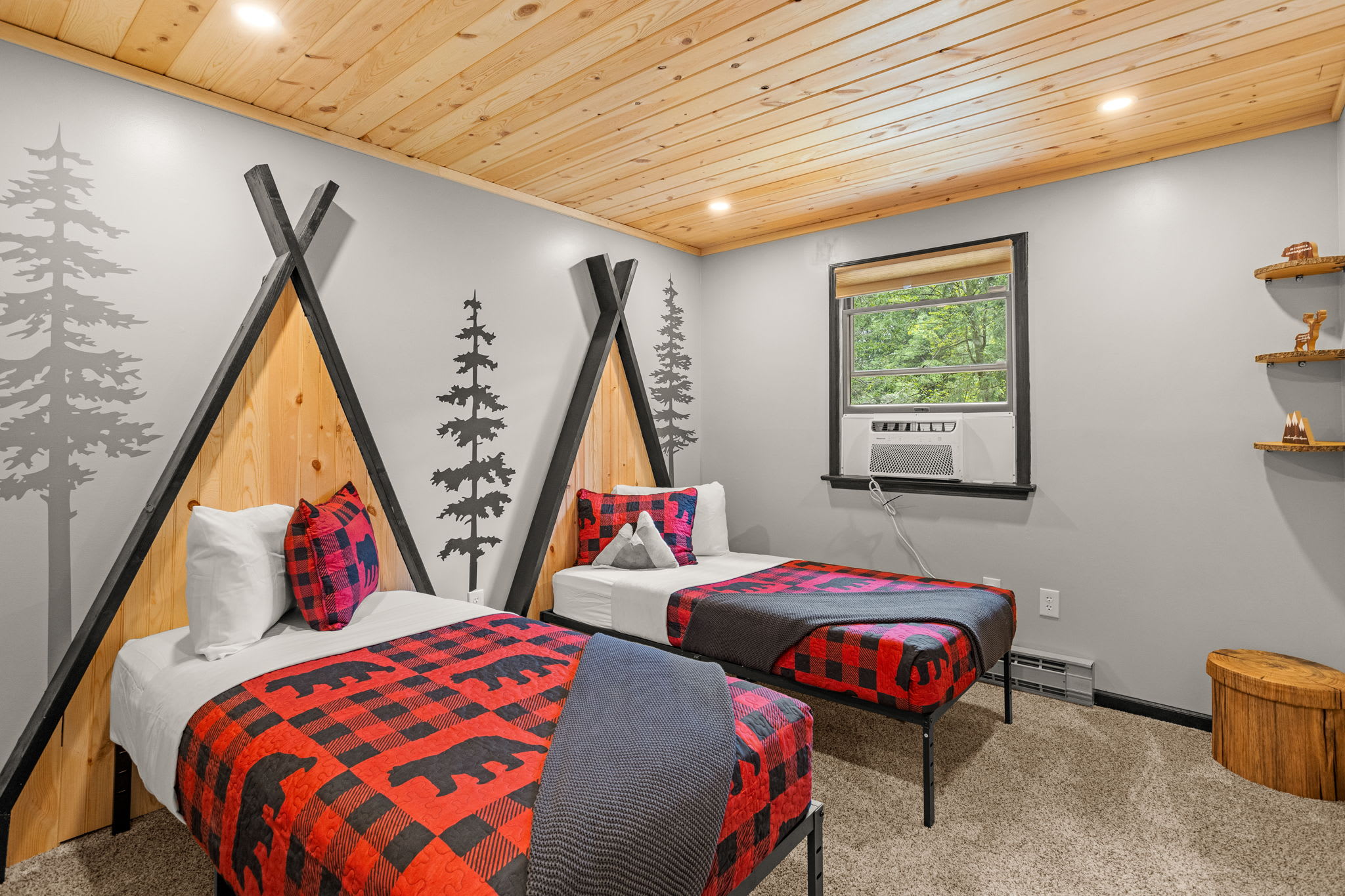 A unique and inviting bedroom featuring teepee-inspired beds, rustic decor, and bold plaid accents for a warm, cabin-style feel.