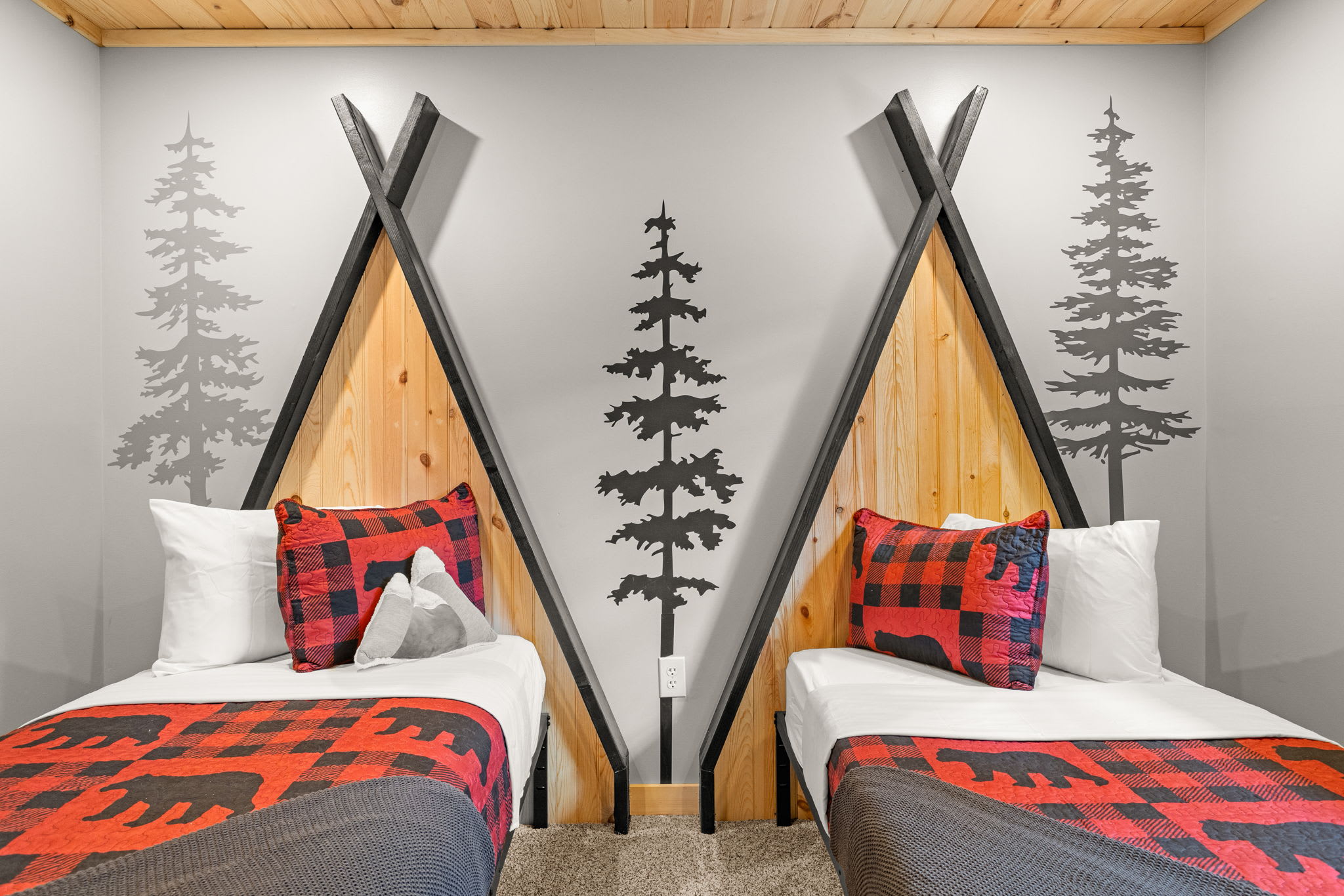 Unique Twin Bedroom with a Campfire Feel – A playful and cozy bedroom featuring teepee-inspired bed frames, nature-themed decor, and vibrant plaid accents for a true mountain retreat.