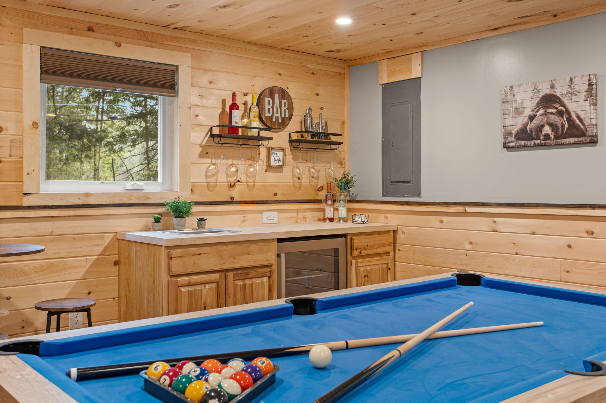 A beautifully designed game room with a sleek pool table, rustic decor, and a bar setup that’s perfect for entertaining.