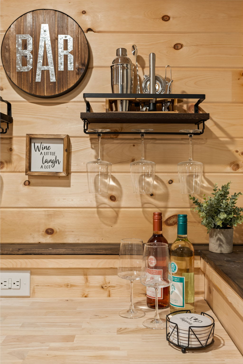  A beautifully designed bar area with decorative accents, open shelving, and a curated selection of spirits.