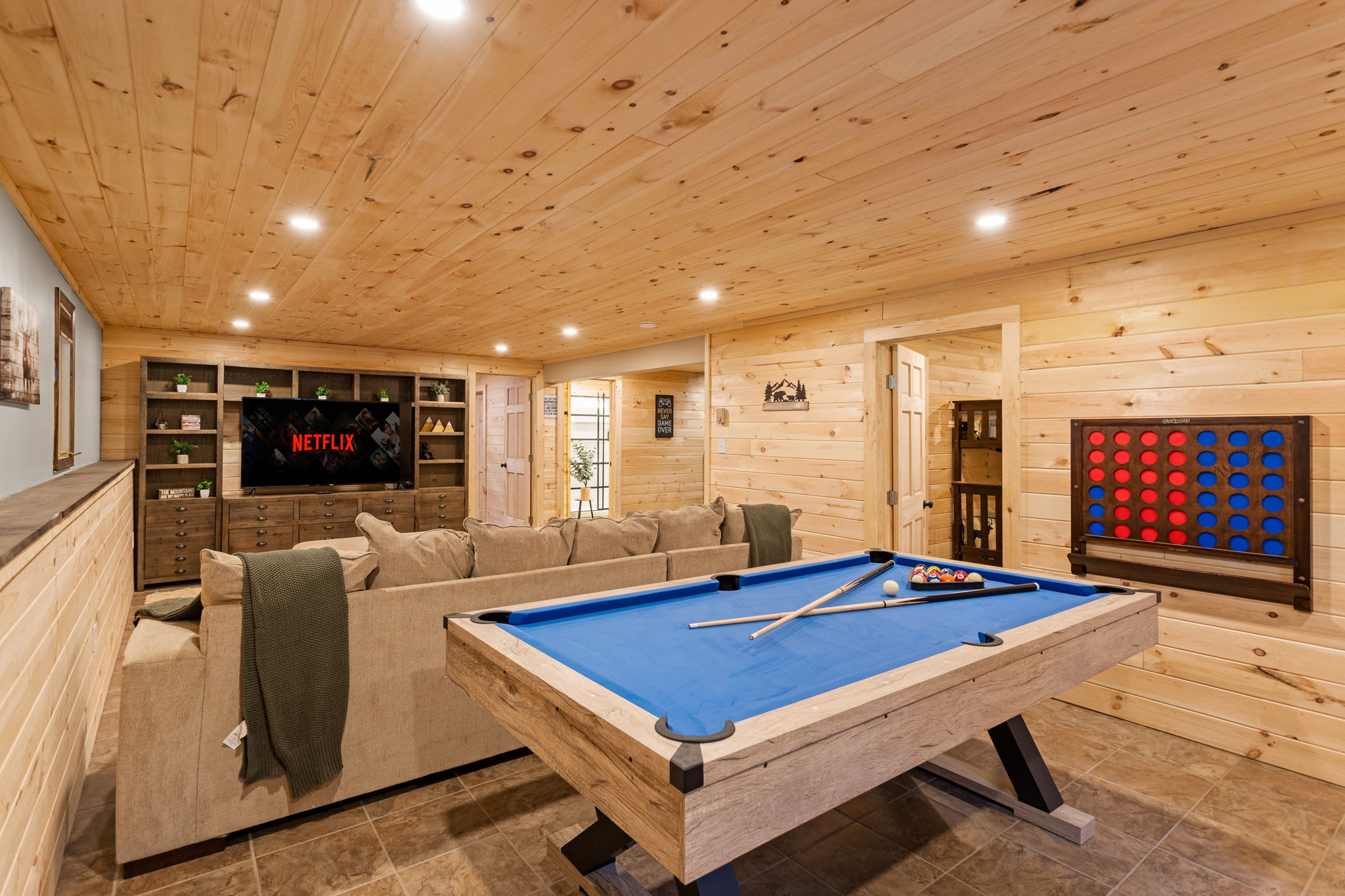 A beautifully designed entertainment space featuring a pool table, built-in shelving, and a cozy seating area for the ultimate game night.