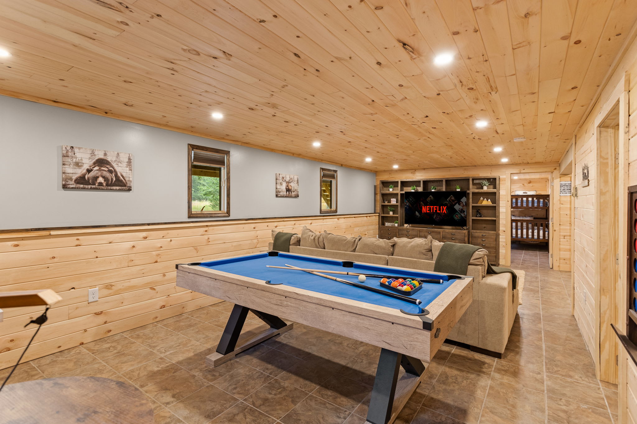 Spacious & Inviting Game Room – A well-lit, open-concept game space with a sleek pool table, warm wooden walls, and a fun, relaxed atmosphere.