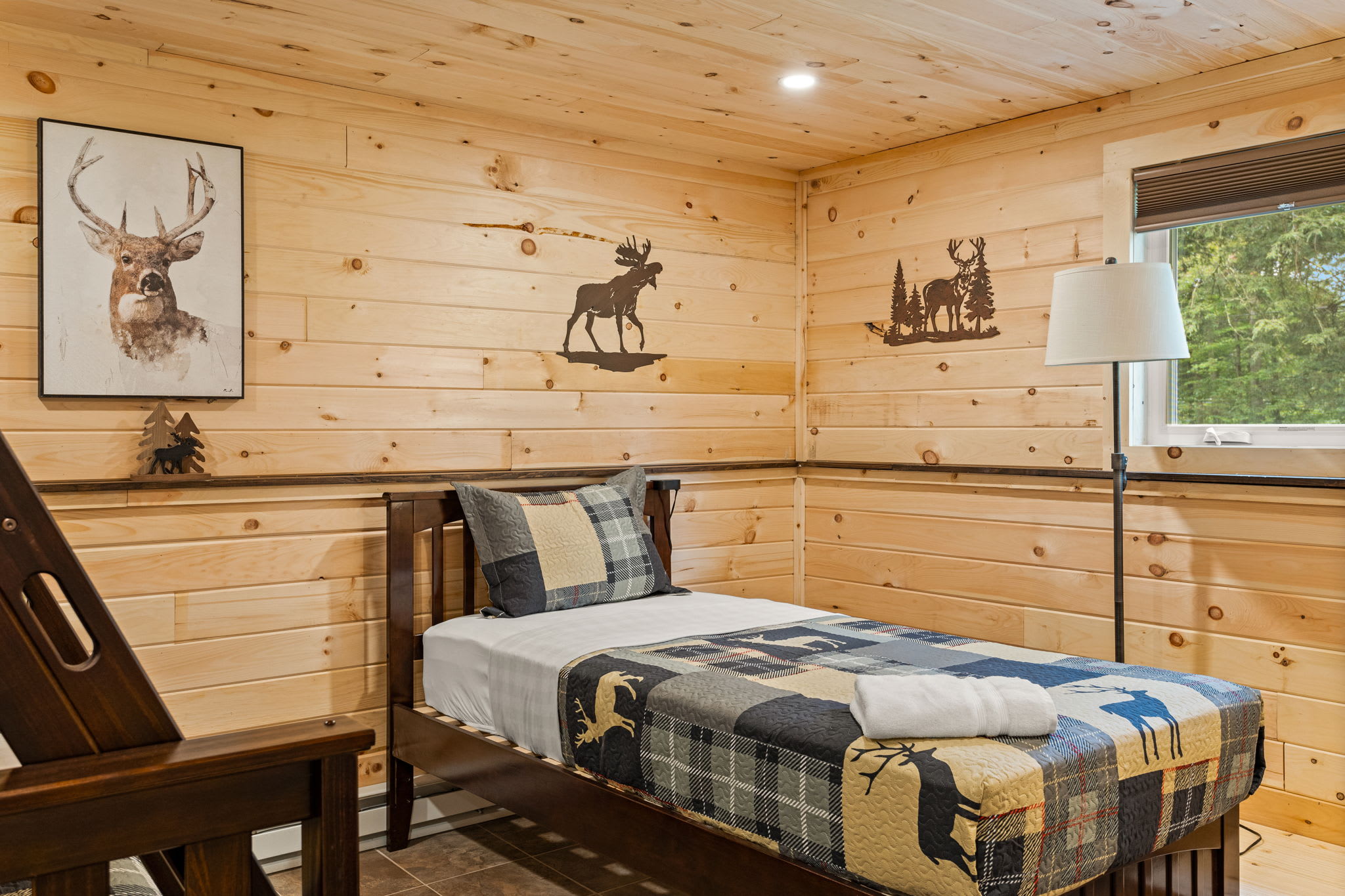 A thoughtfully designed bedroom with cabin-themed decor, soft lighting, and a mix of single and bunk beds for flexible sleeping arrangements.