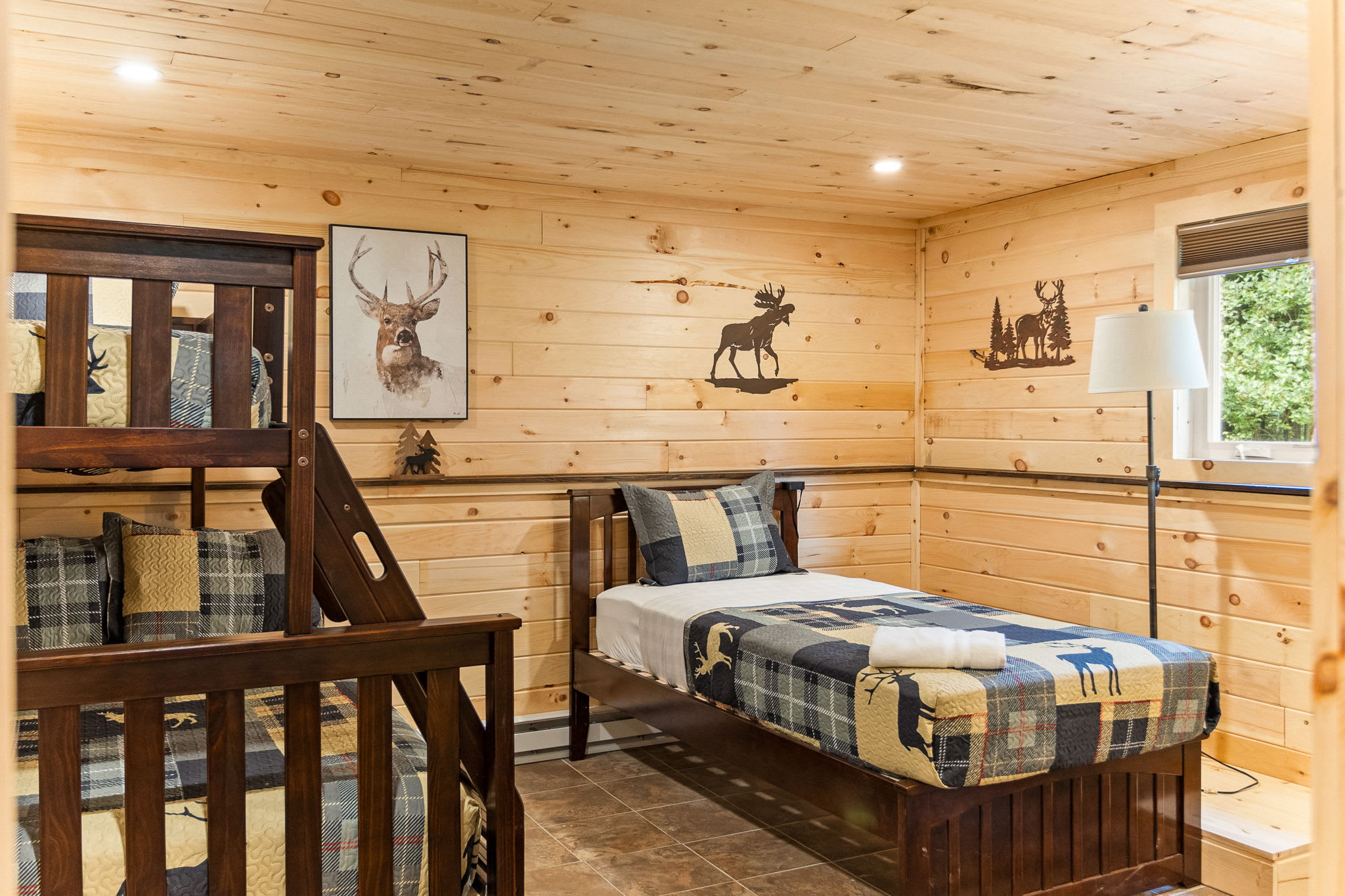 Charming Cabin-Inspired Bedroom – A cozy and rustic sleeping space featuring warm wood paneling, bunk beds, and plaid bedding for a true lodge feel.