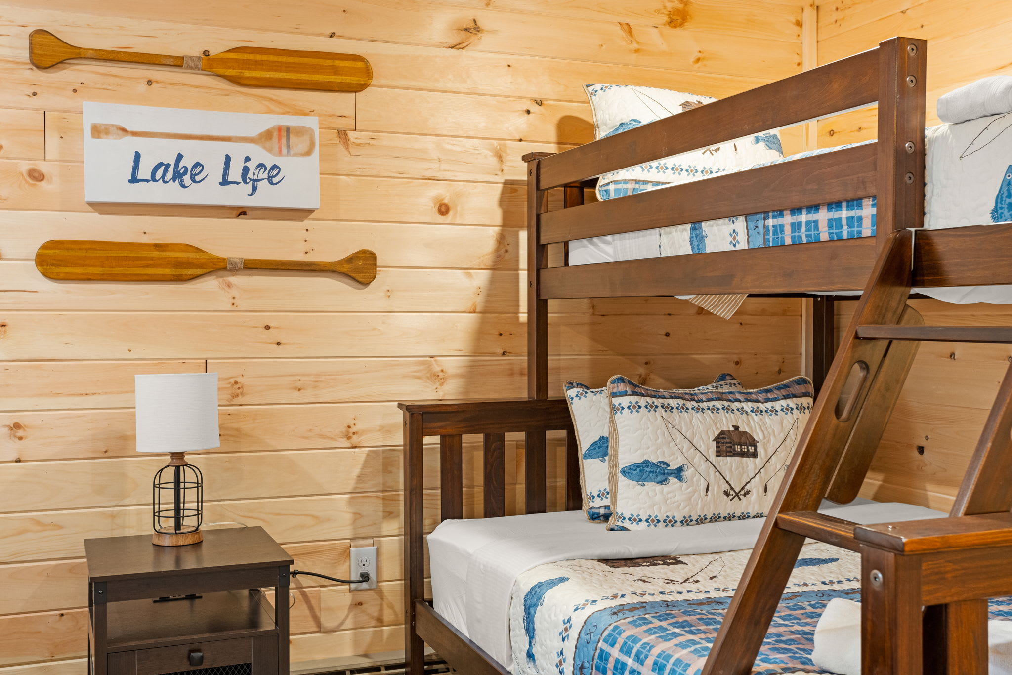A warm and inviting bunk bed setup with playful lake-themed decor, perfect for a cozy cabin stay.
