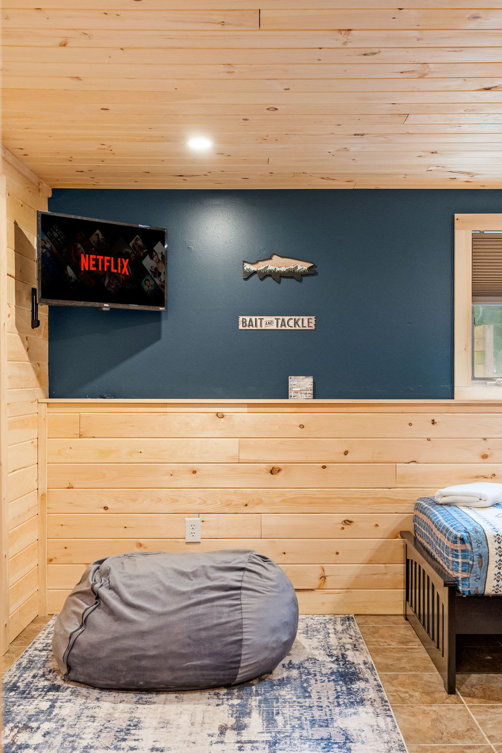 A cozy bedroom featuring a bean bag lounging area, a mounted TV, and a perfect mix of style and function.