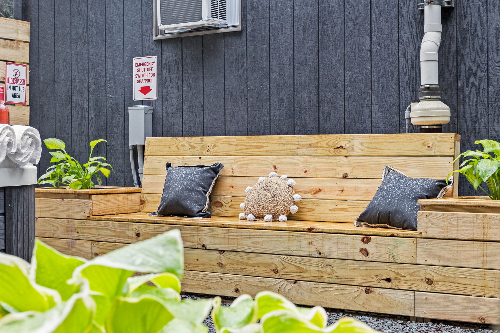 Cozy Outdoor Bench Seating – A stylish wooden bench built into the outdoor space, complete with soft pillows and plants, creating a charming and peaceful nook.