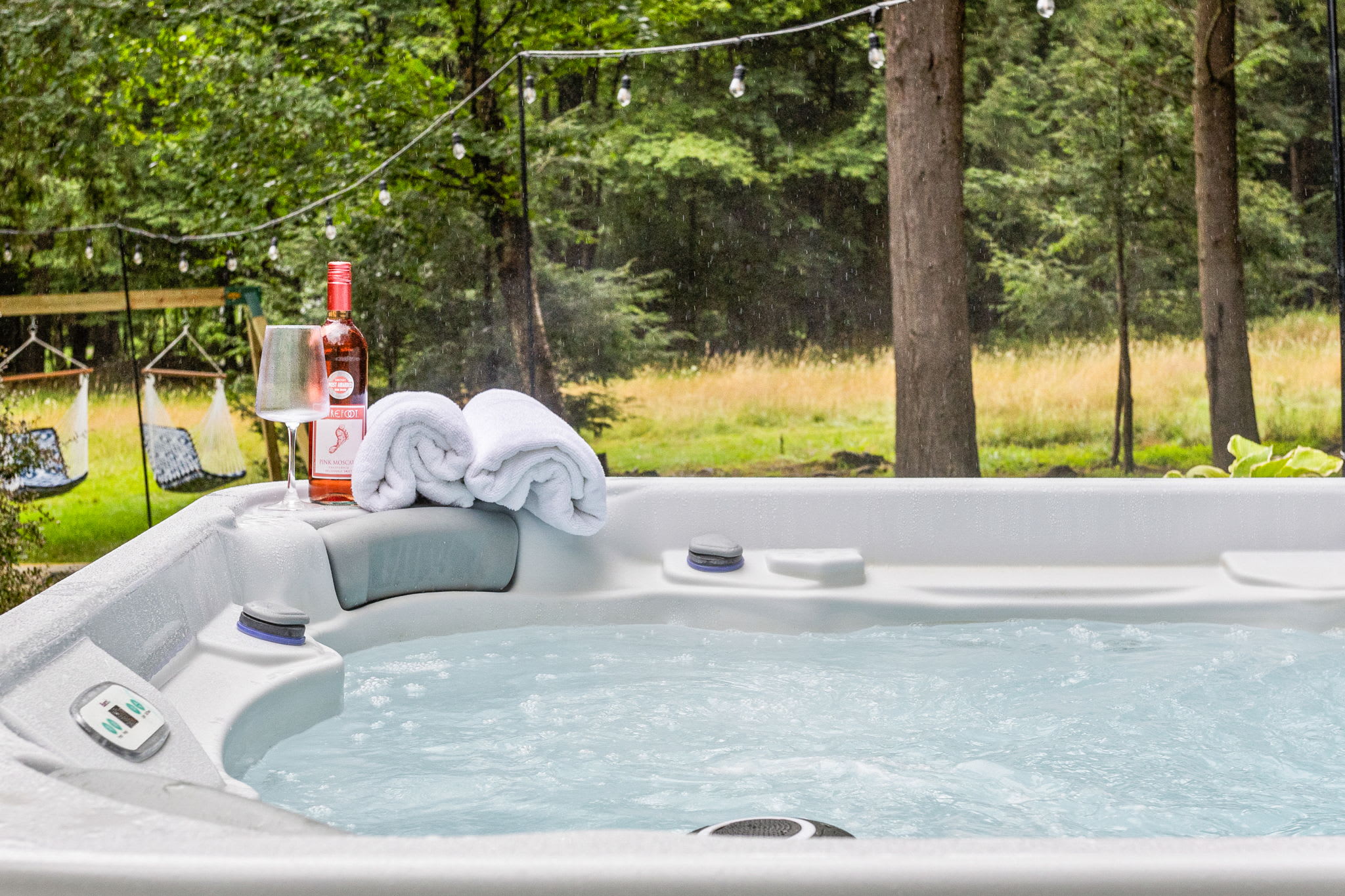 Tranquil Hot Tub with Scenic Views – A spacious and inviting hot tub surrounded by nature, offering the perfect setting to relax and enjoy the peaceful forest backdrop.

