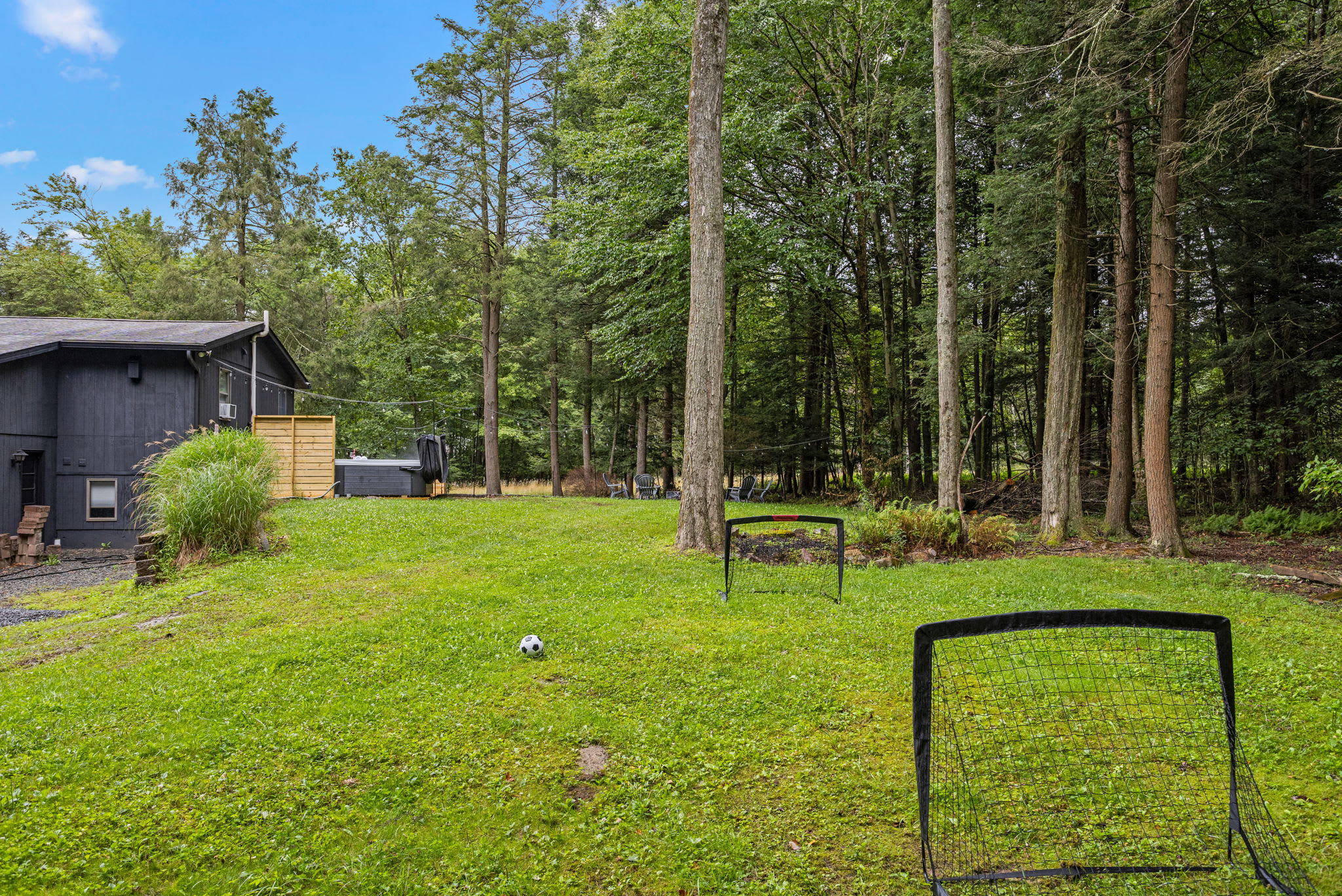 Fun & Relaxing Outdoor Play Space – A backyard designed for entertainment, complete with soccer goals and open space for enjoying games with family and friends.