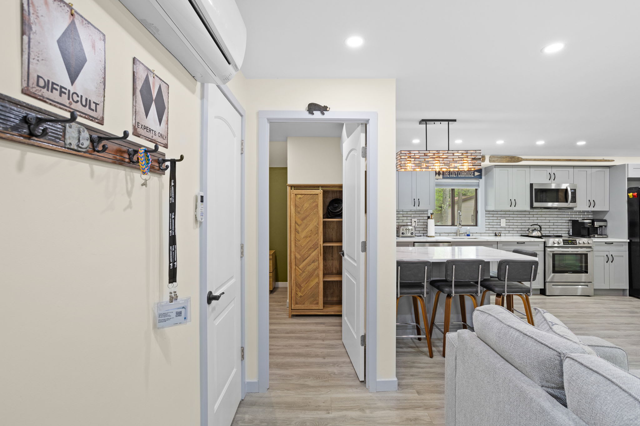This inviting space seamlessly connects the living room, kitchen, and hallway, creating a spacious yet cozy atmosphere. The warm tones and stylish accents make it feel just like home.