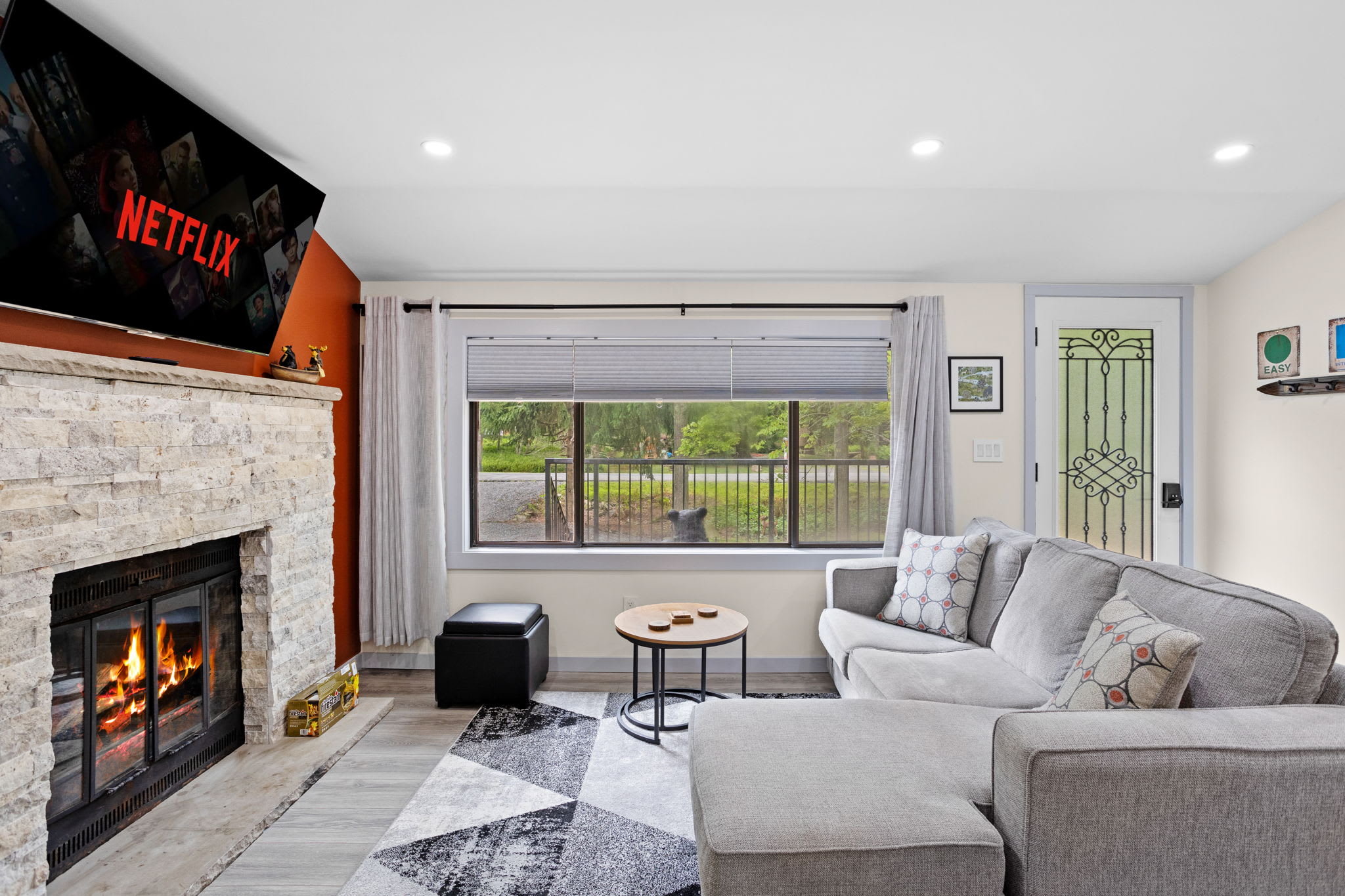 Natural light pours into this welcoming space, highlighting the stone fireplace and inviting sectional. Kick back, watch your favorite Netflix shows, or simply enjoy the serene view from the large front window.