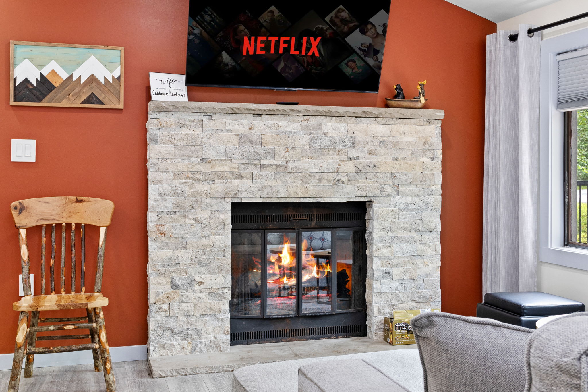 Enjoy the warmth of a crackling fire while streaming your favorite shows. The textured stone fireplace, rustic wall art, and modern furnishings create a cozy yet sophisticated ambiance.