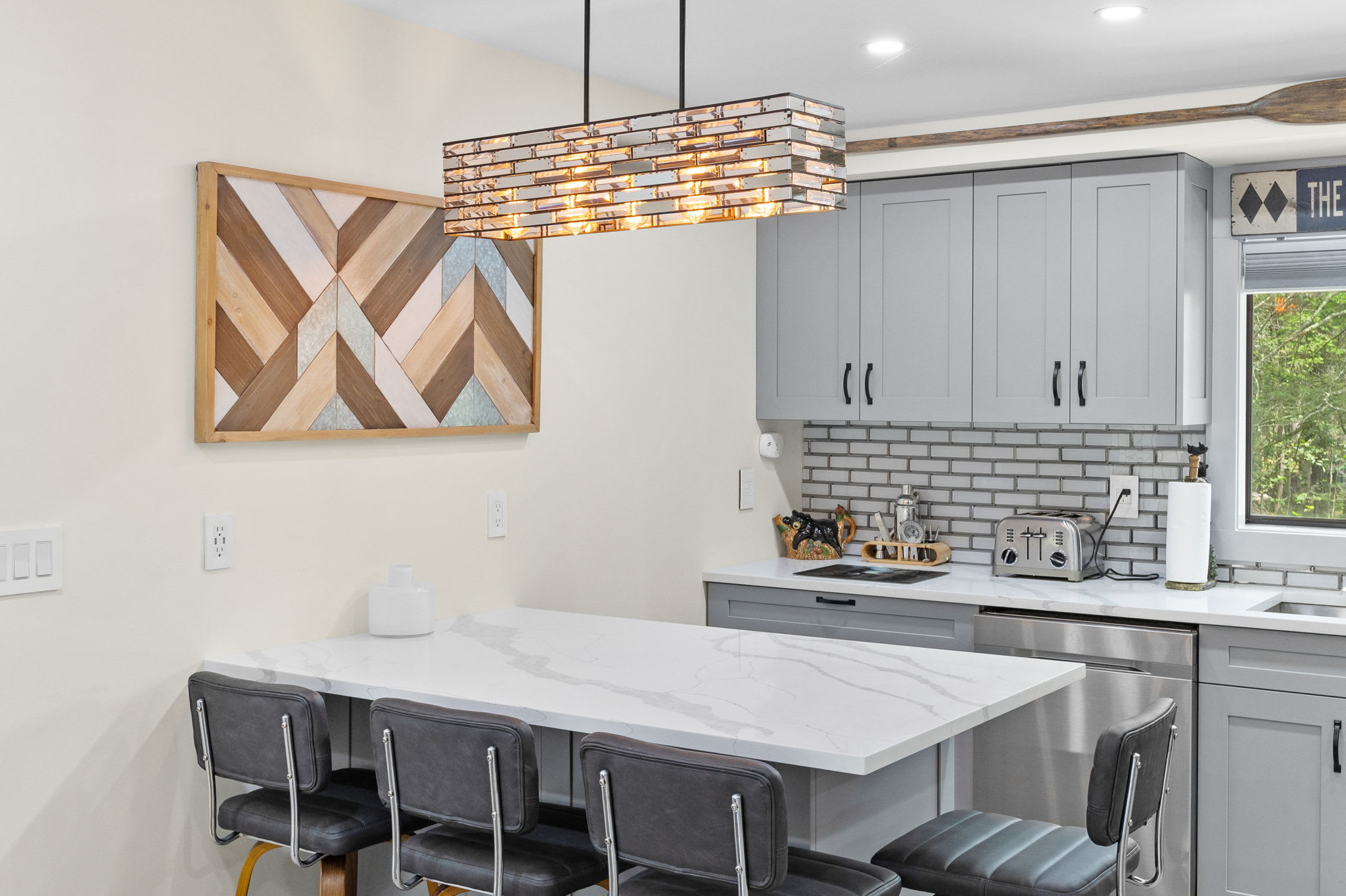 Dine in style under this striking chandelier. The combination of wood textures, clean lines, and warm lighting makes for the perfect mealtime setting.