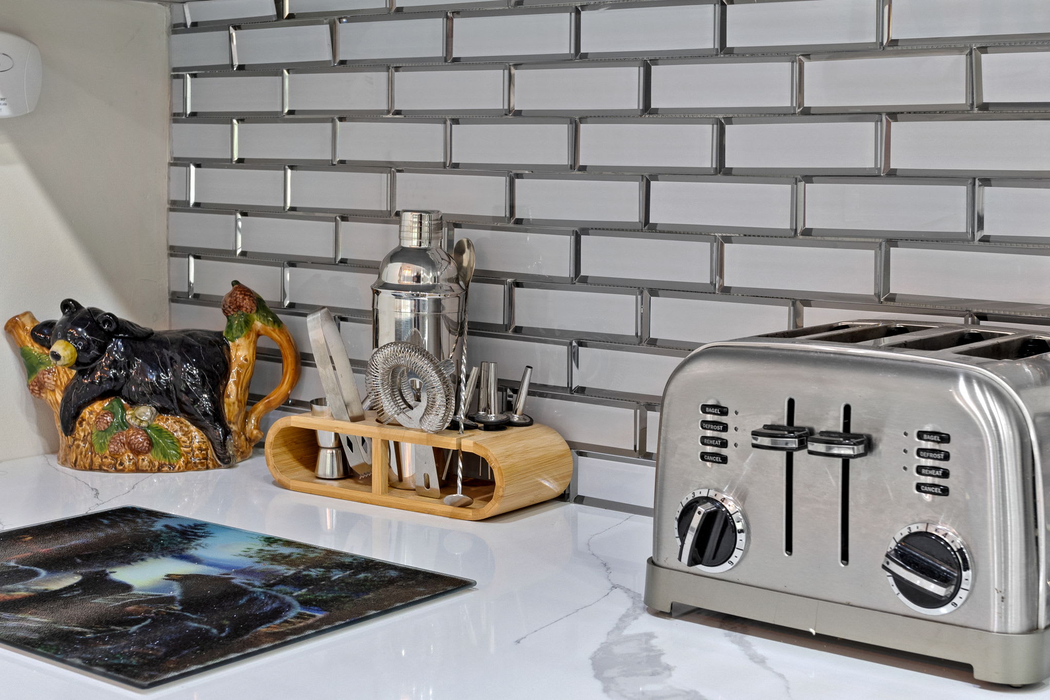 A stylish and functional kitchen setup featuring a stainless steel toaster, cocktail-making essentials, and charming rustic decor that adds a cozy, cabin-inspired touch.
