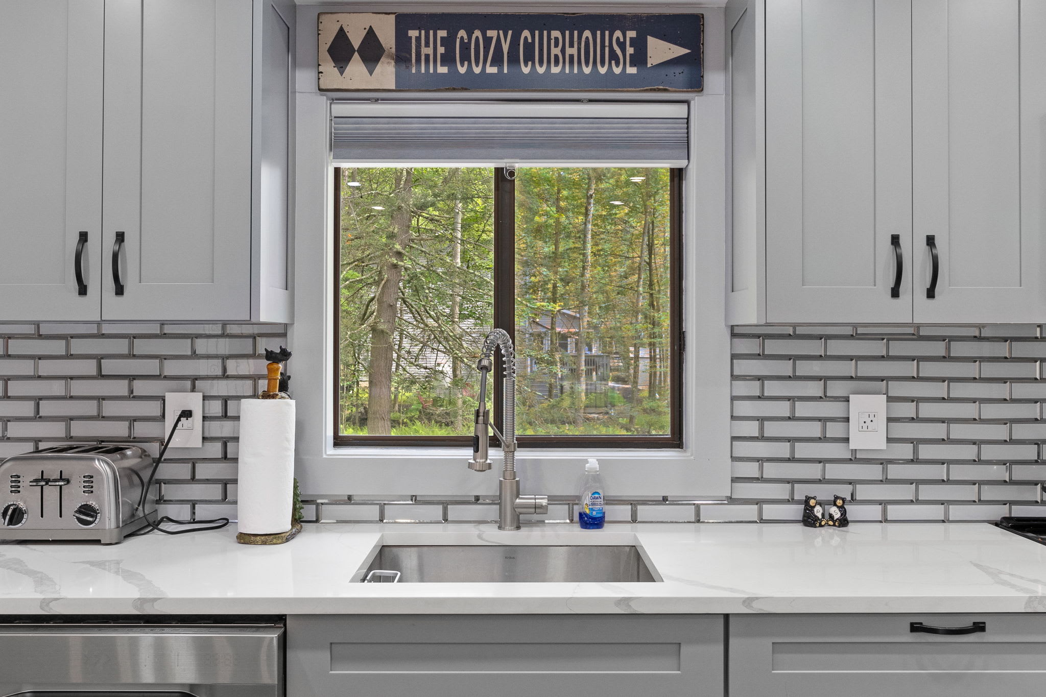 Wash dishes with a view! The window over the sink provides a peaceful scene of the surrounding nature, adding to the home’s inviting and relaxing atmosphere.