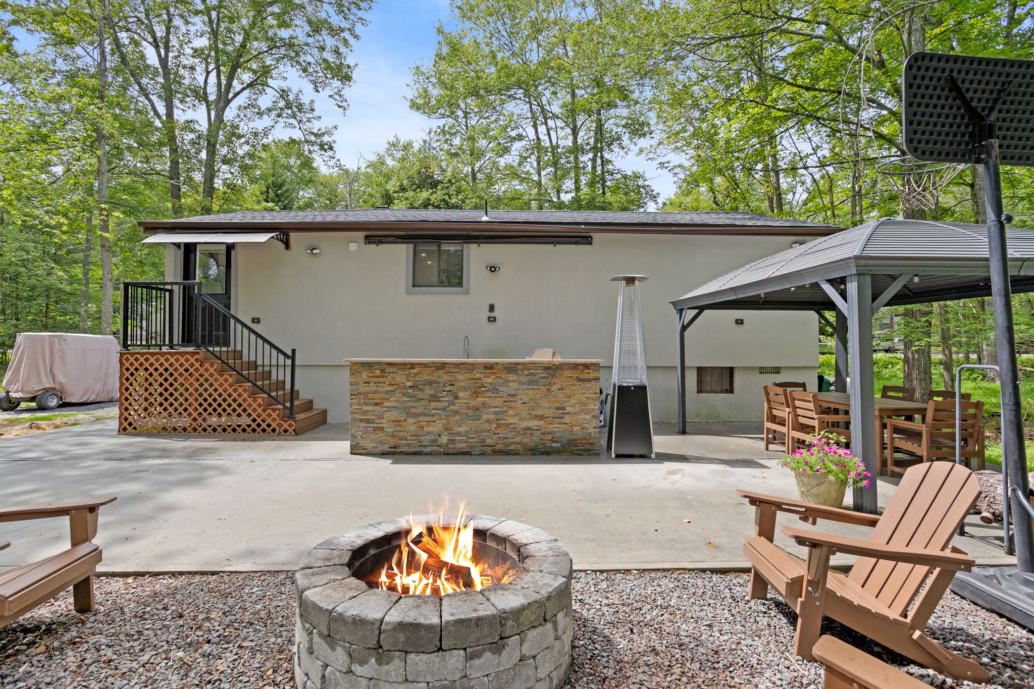 Roast marshmallows, share stories, and enjoy the warmth of the firepit in this inviting backyard. Comfortable Adirondack chairs make it the ideal spot for relaxation.