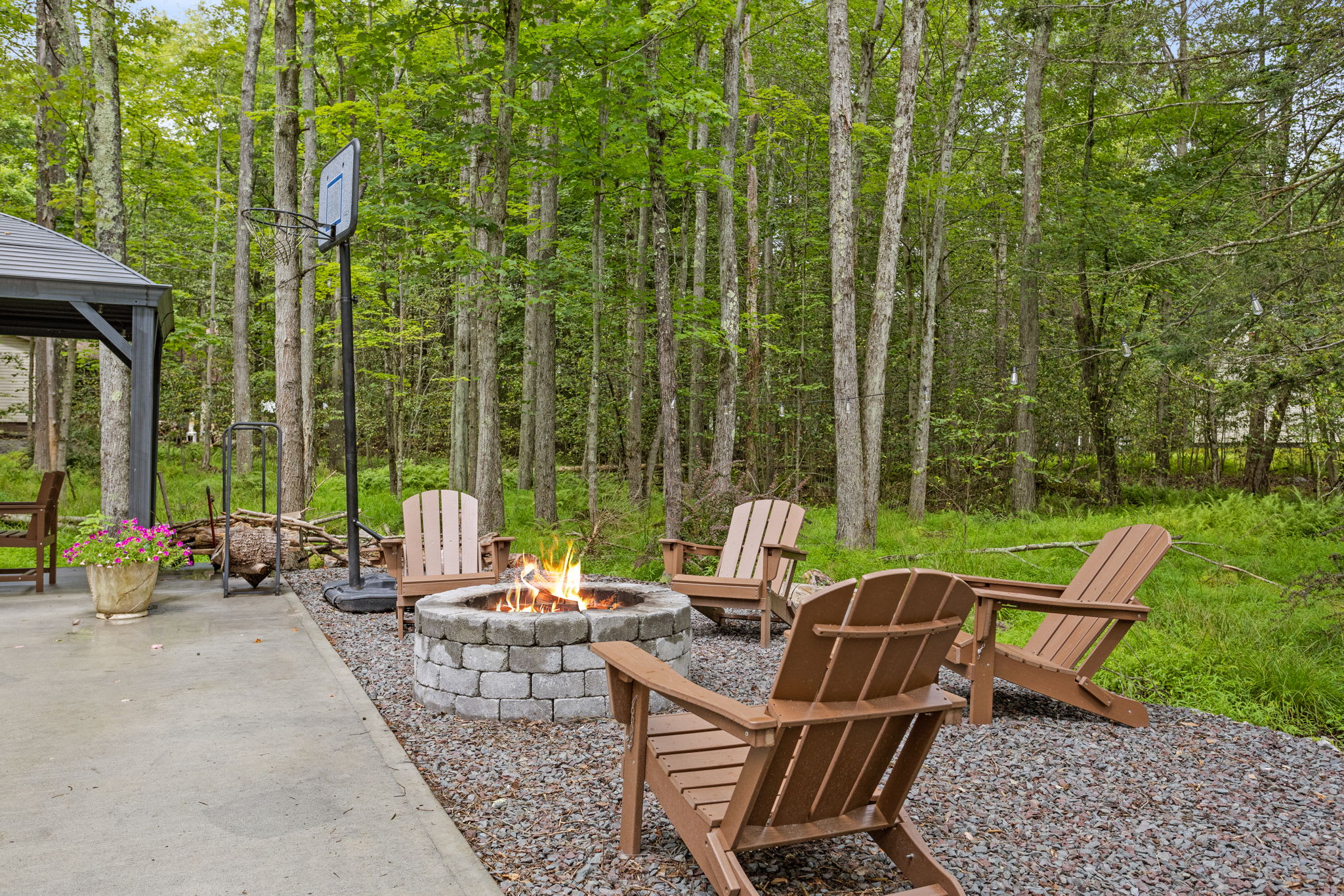 This cozy firepit area, complete with comfortable Adirondack chairs, is the perfect place to unwind, enjoy good company, and soak in the sounds of nature.