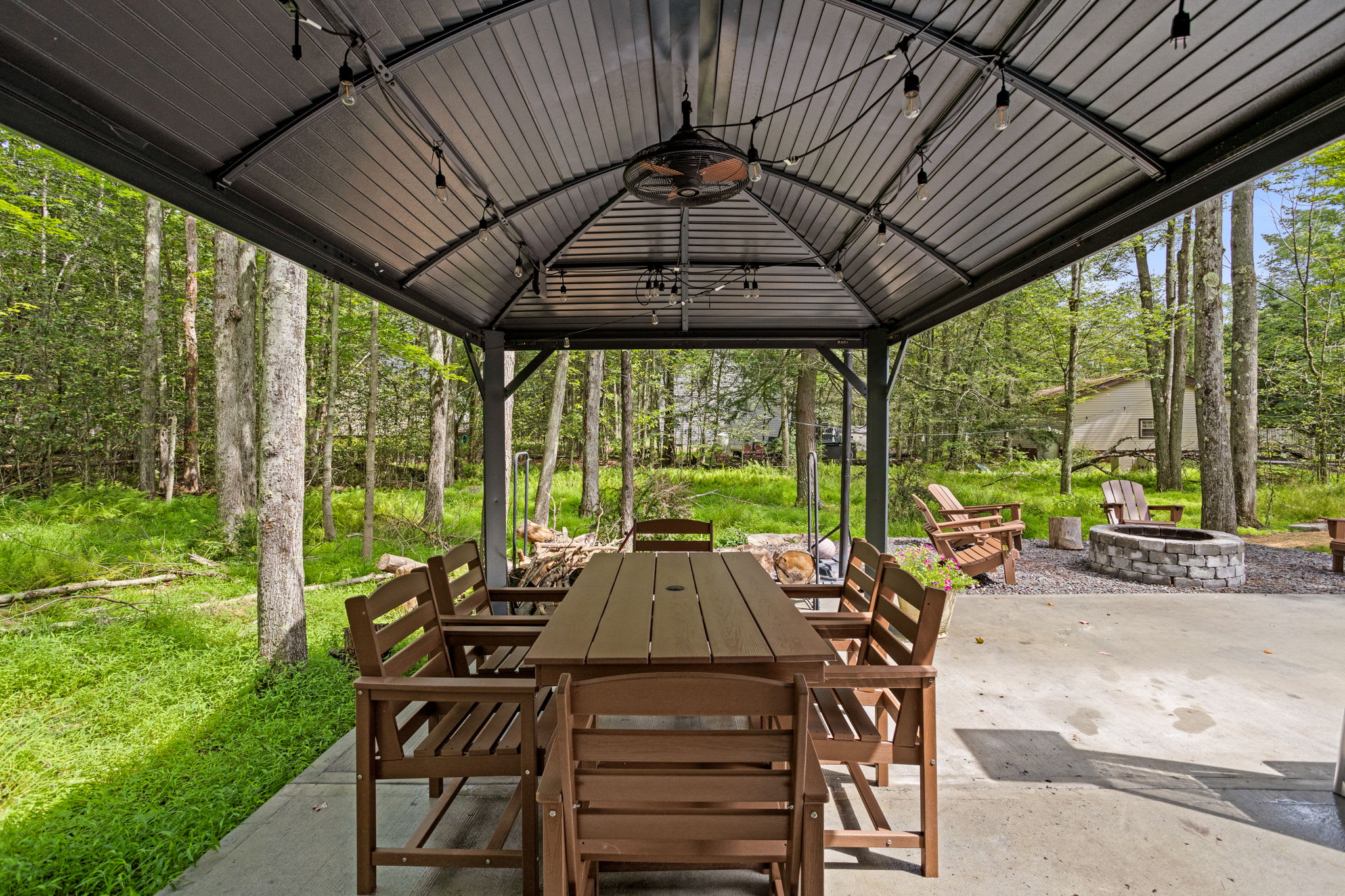 Whether it's a family dinner, a casual brunch, or a late-night chat by the fire, this covered dining area is the ultimate space to connect and unwind.
