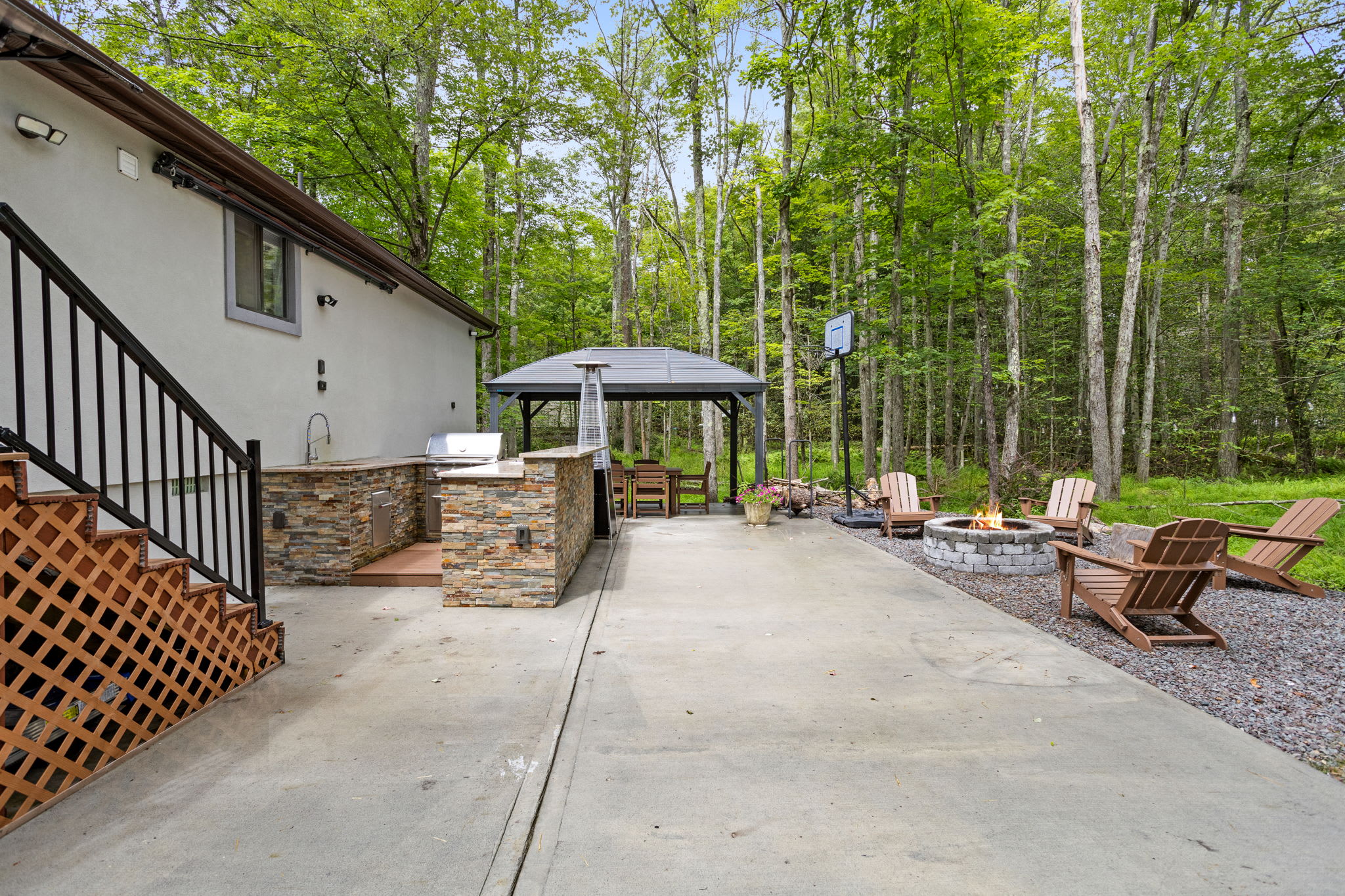 Designed for entertaining and relaxation, this backyard features a full outdoor kitchen, a dining gazebo, and a firepit, ideal for making memories in nature.