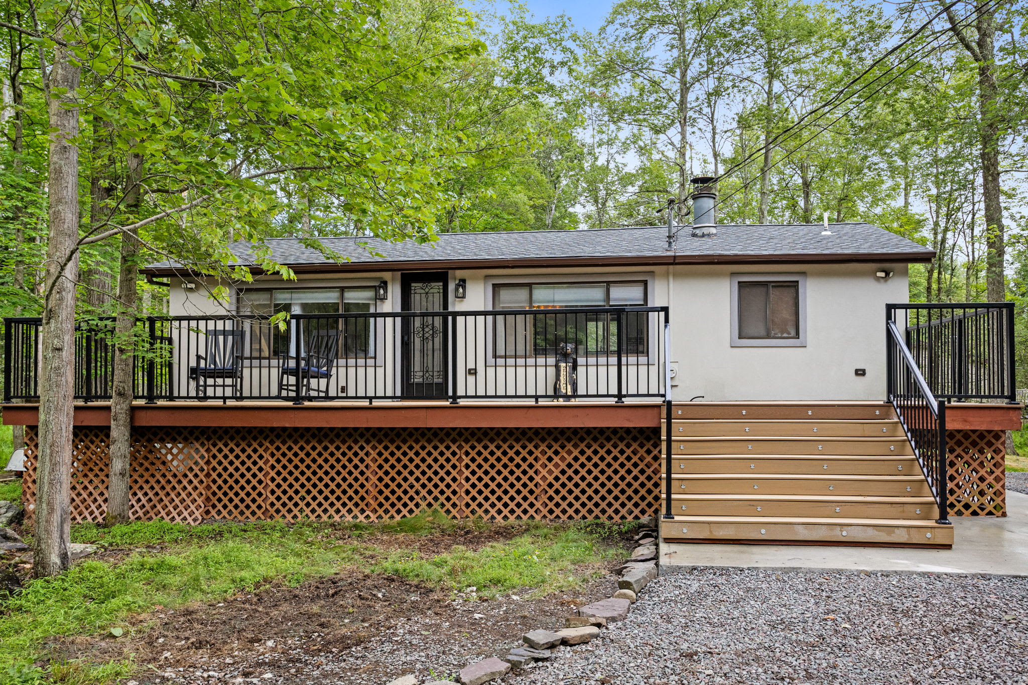 This elevated deck with classic black railings offers a great spot to sip your morning coffee or enjoy the fresh forest air while rocking in a chair.