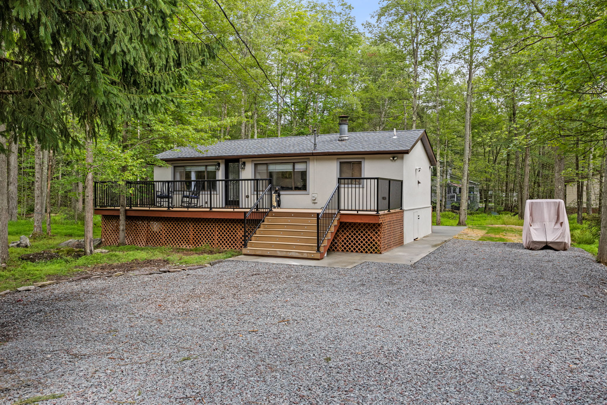 Surrounded by nature, this cozy home boasts an inviting front deck, ample outdoor space, and a quiet, secluded setting for a perfect getaway.