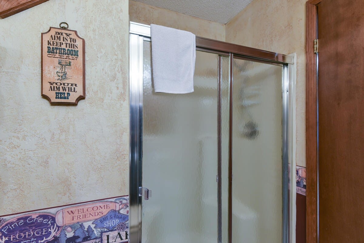 Main bathroom with step in shower with small built in seat.