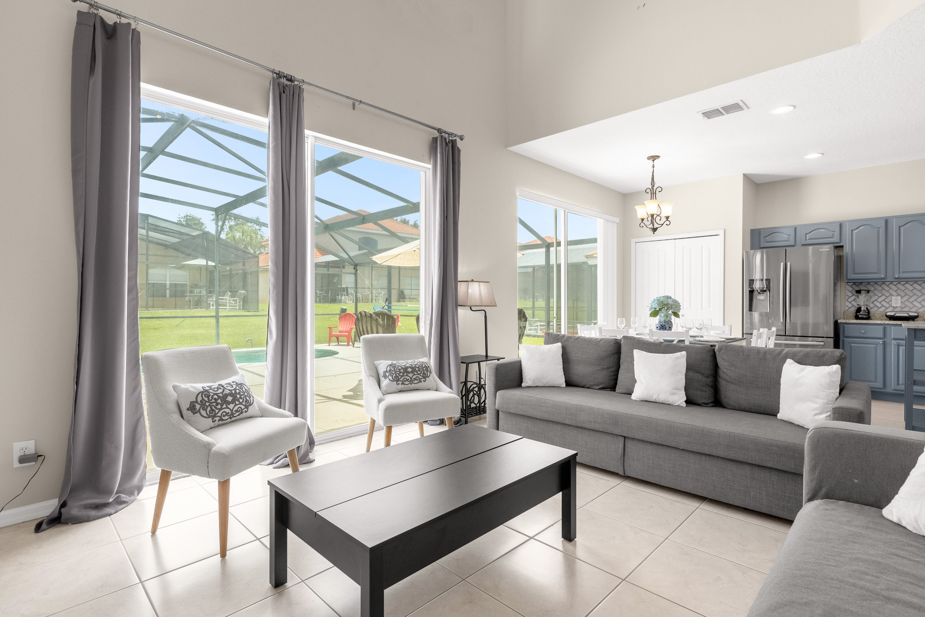 Bright Living Room With Comfortable Seating And Poolside Views
