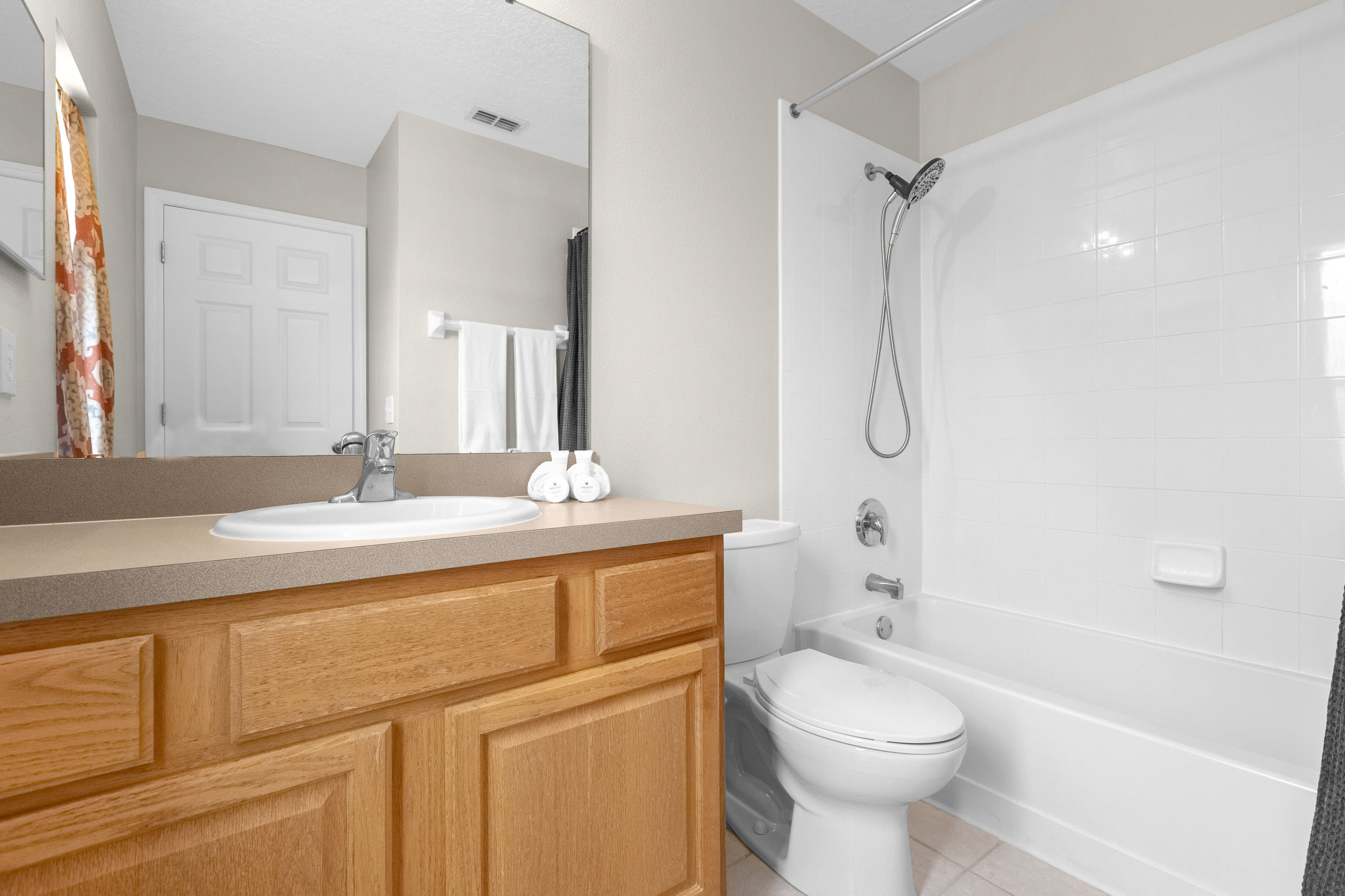 Spacious Bathroom Featuring Elegant Fixtures And Ample Lighting