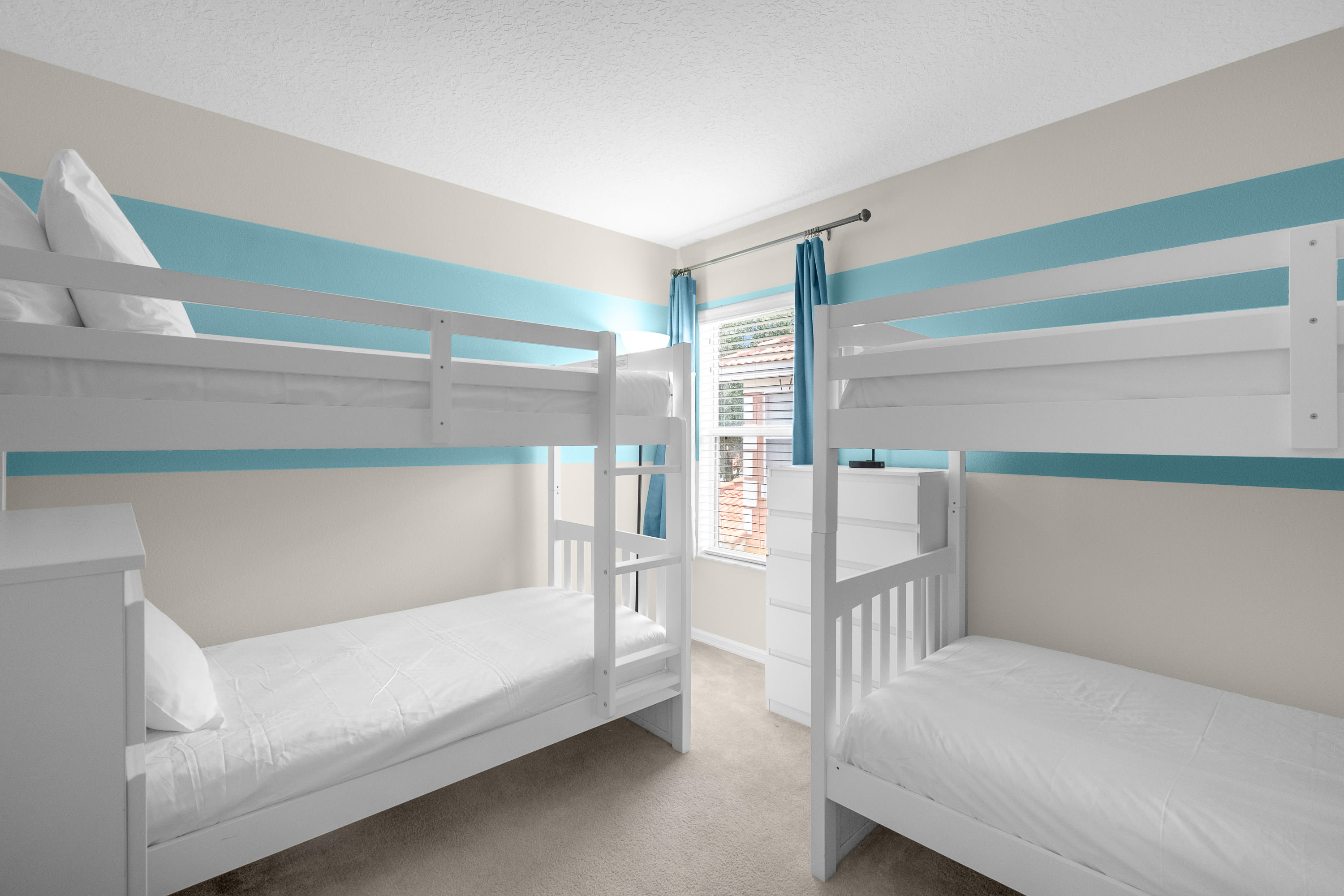 Fun Bunk Room With Bright Blue Accents And Comfortable Beds