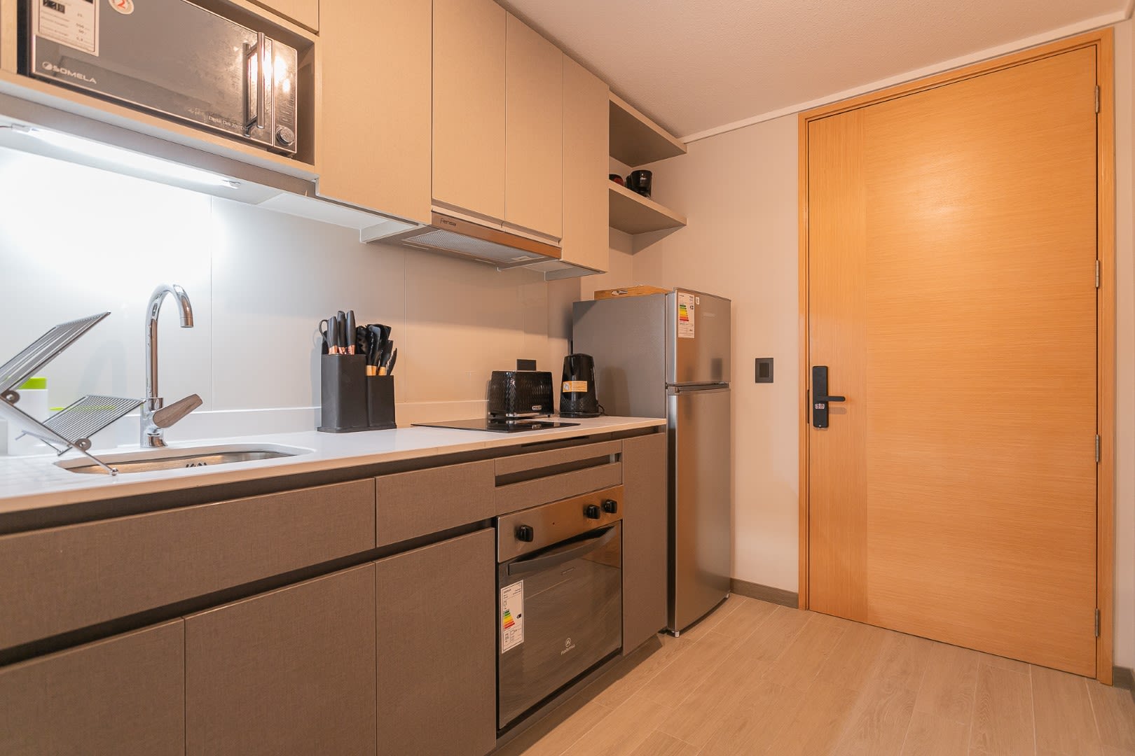 Modern kitchenette with essential appliances and stylish design, perfect for cozy meals in a chic studio apartment.