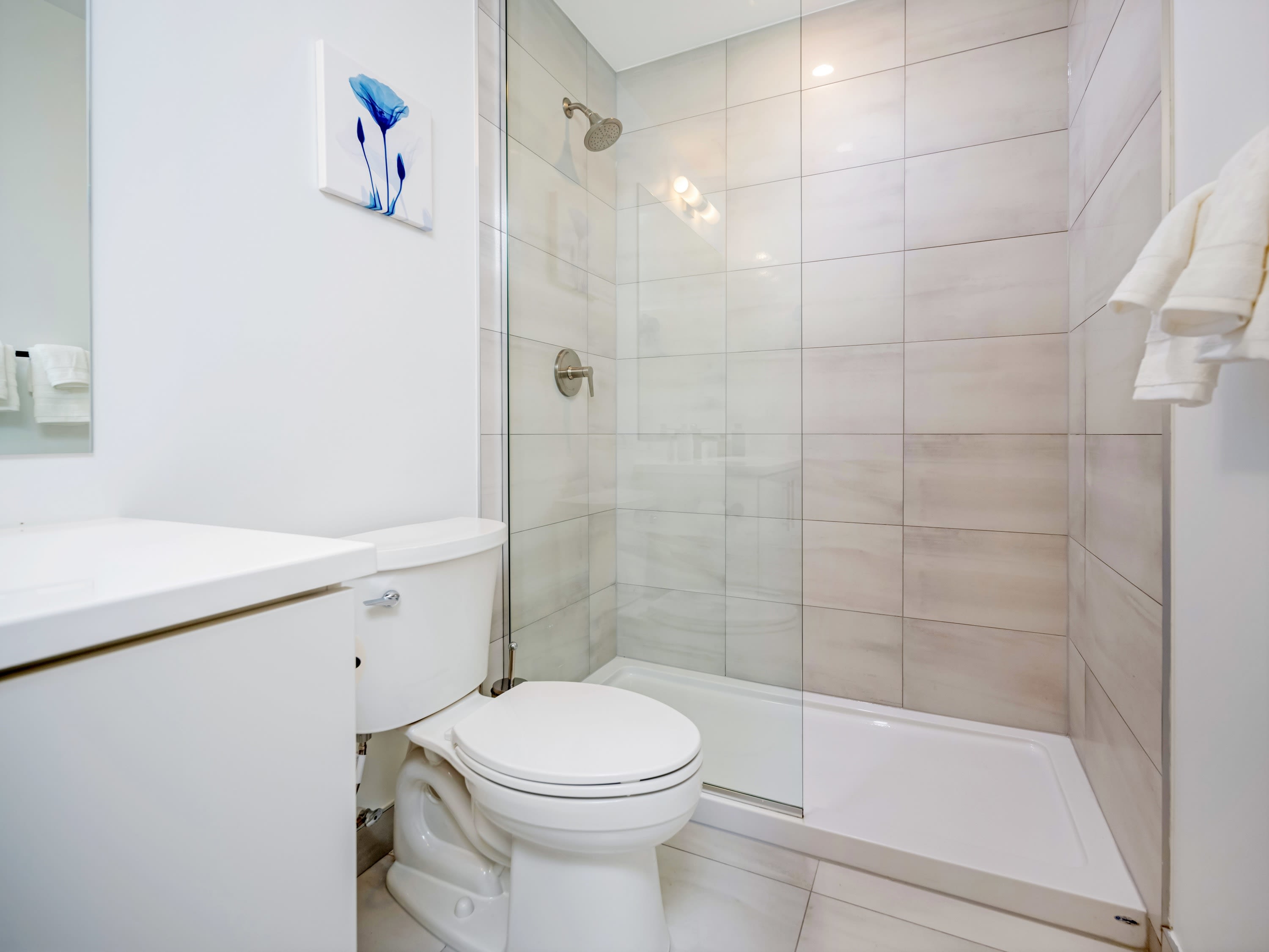 Bathroom Featuring A Spacious Standing Shower And Sleek Tilework