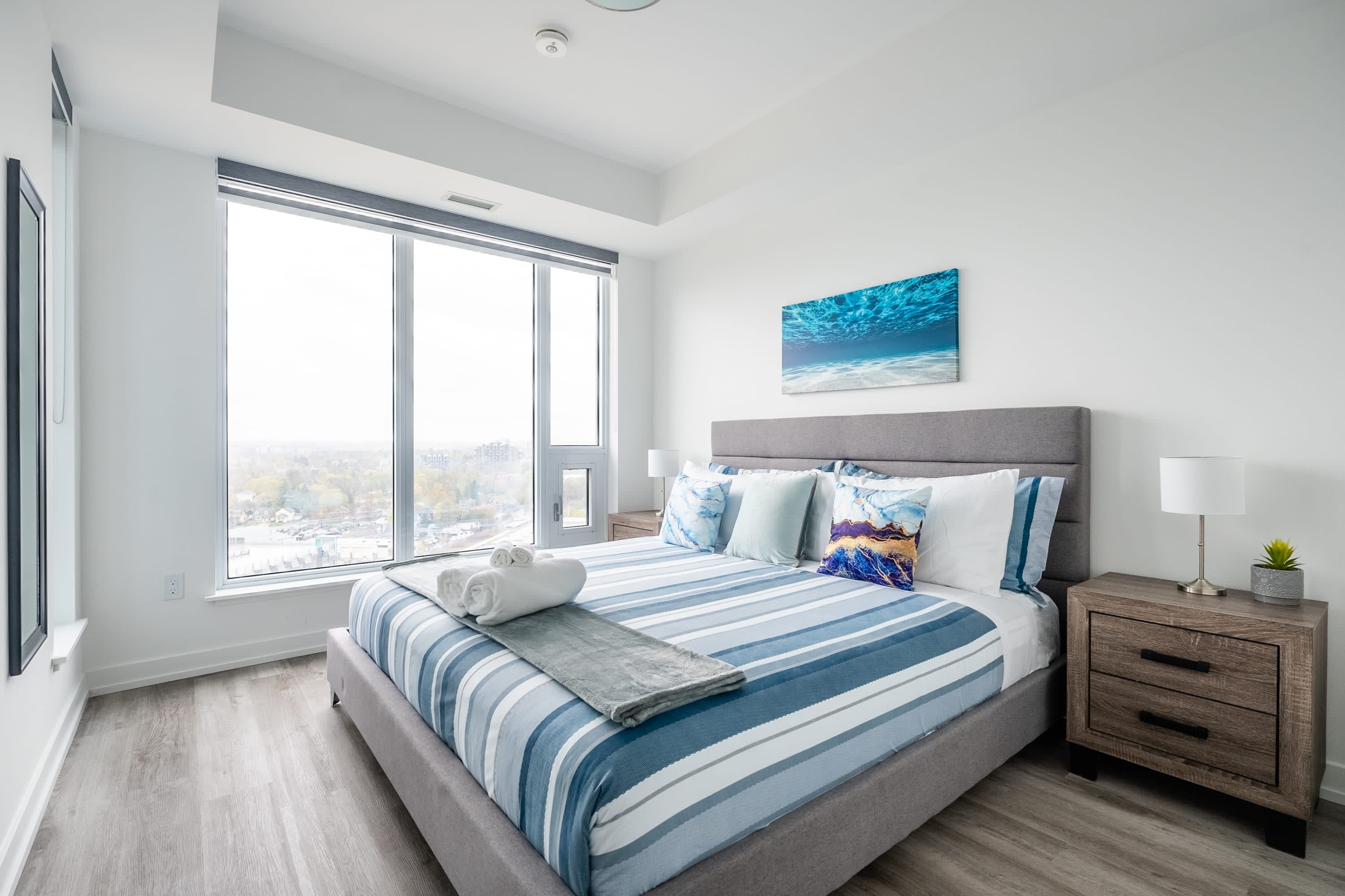 Spacious Bedroom With King Size Bed And Natural Light Streaming Through Large Windows