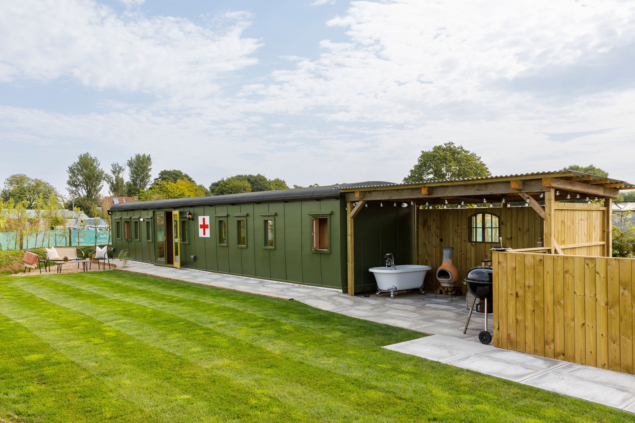 Step into the past with our WW2 ambulance train carriage, complete with cozy outdoor seating. Perfect for a peaceful retreat.