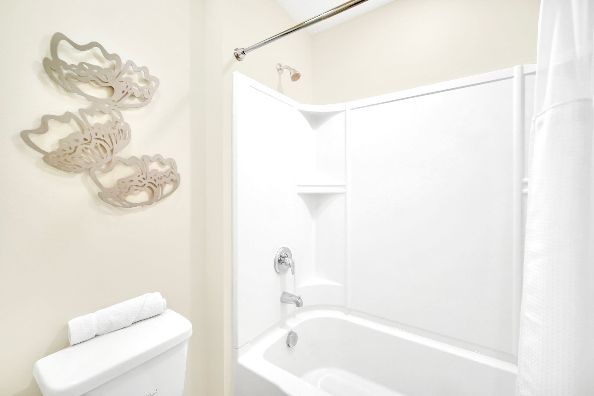Bright Bathroom Featuring A Sleek Bathtub And Elegant Wall Decor
