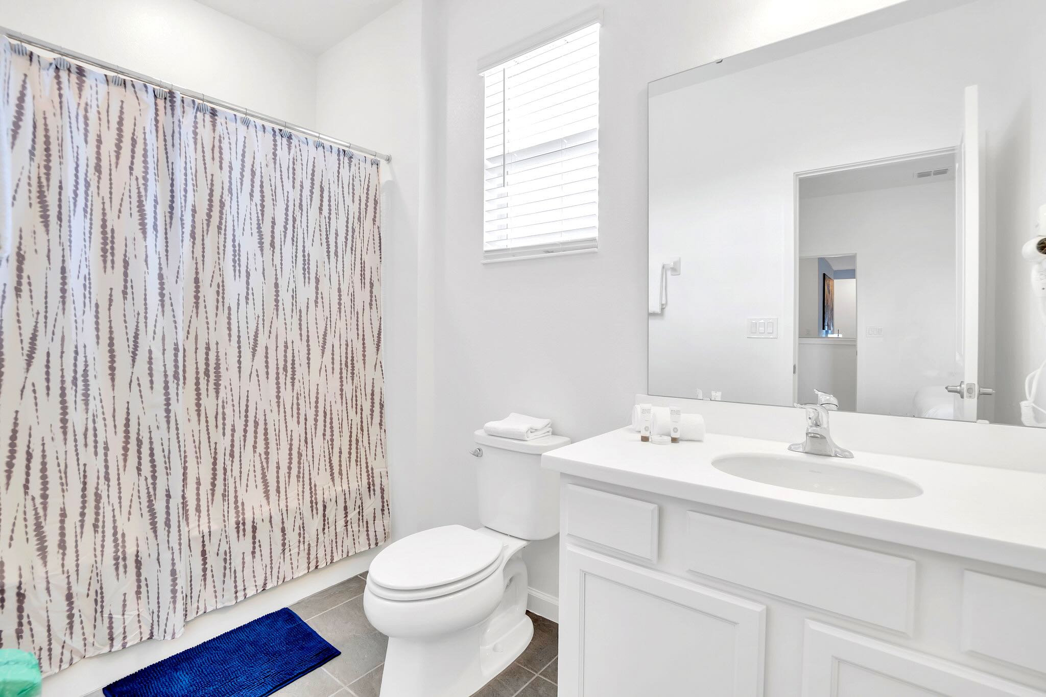 Bright Bathroom With Shower And Large Vanity Mirror