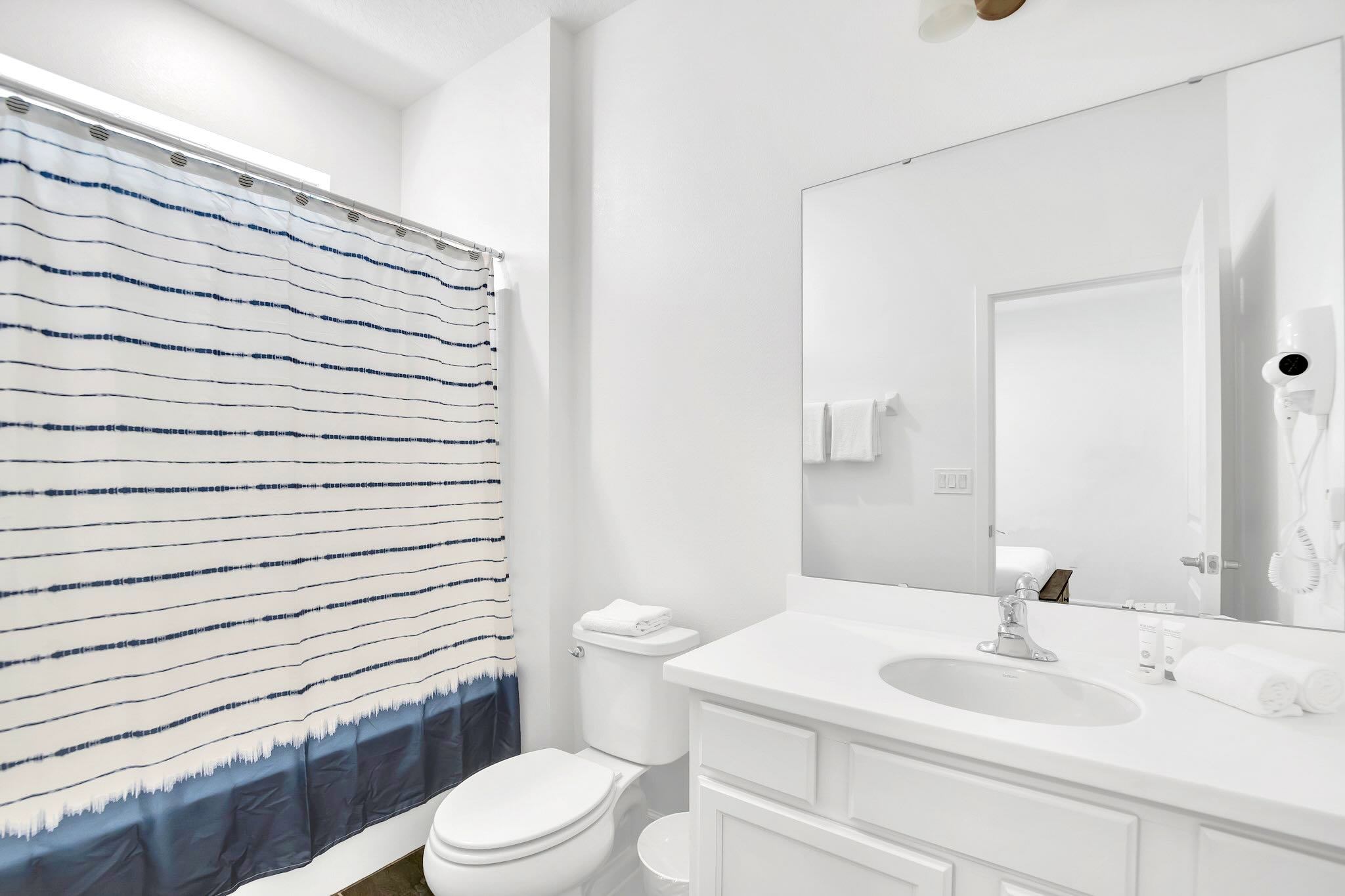 Bathroom Featuring Dual Sinks And Tiled Shower
