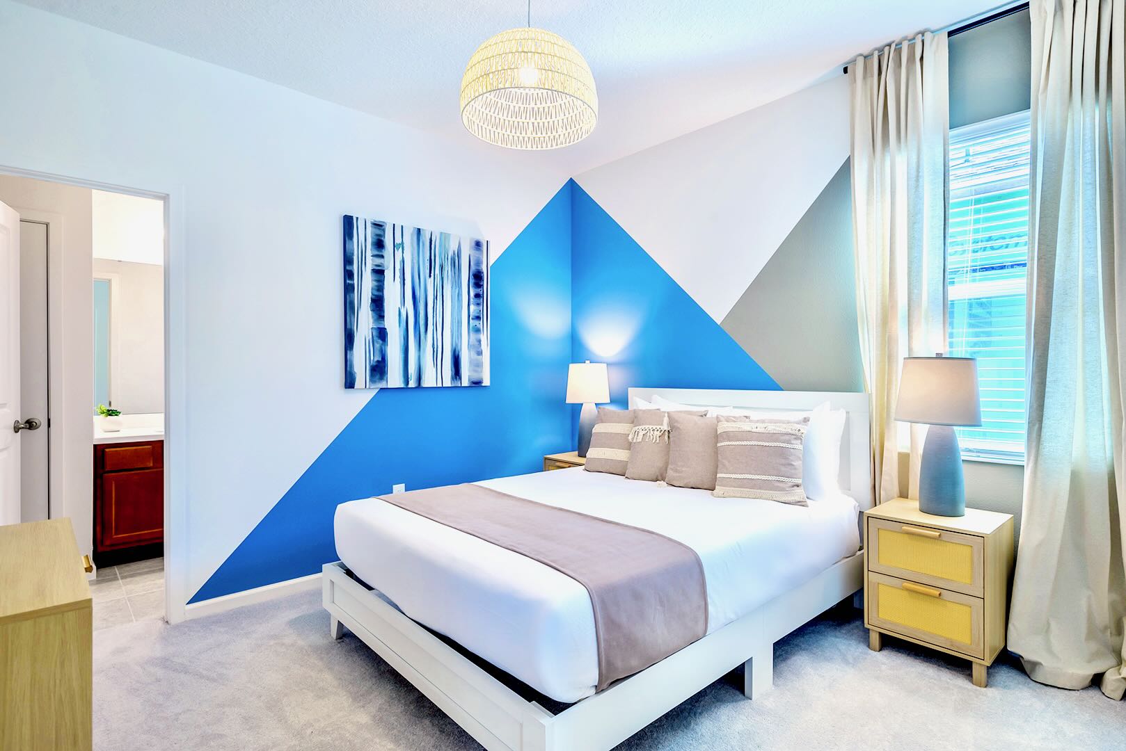 Stylish Room Featuring A Queen Bed, Bold Wall Art, And Sleek Furnishings
