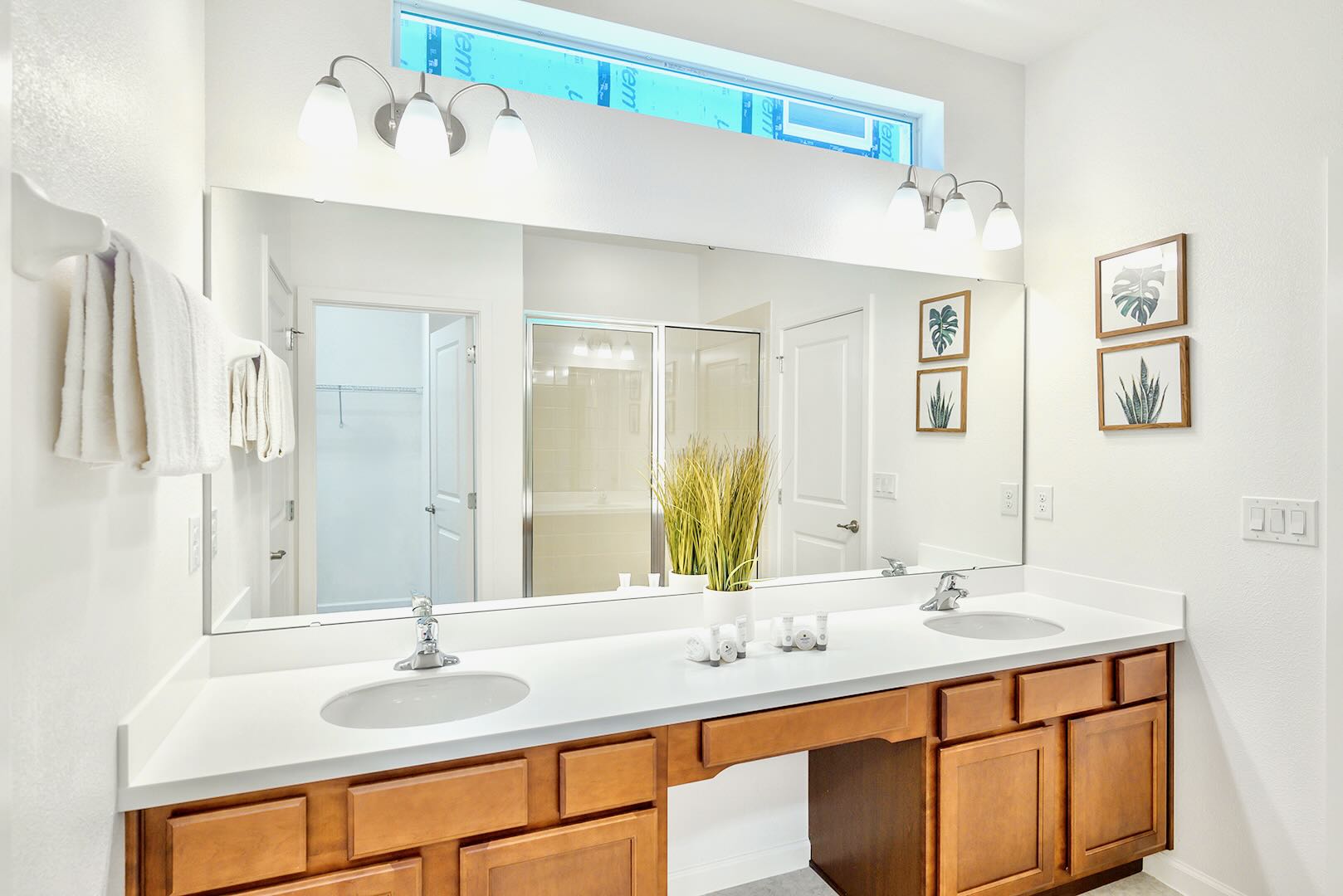 Luxurious Bathroom With Dual Vanities, Bright Lighting, And Modern Fixtures