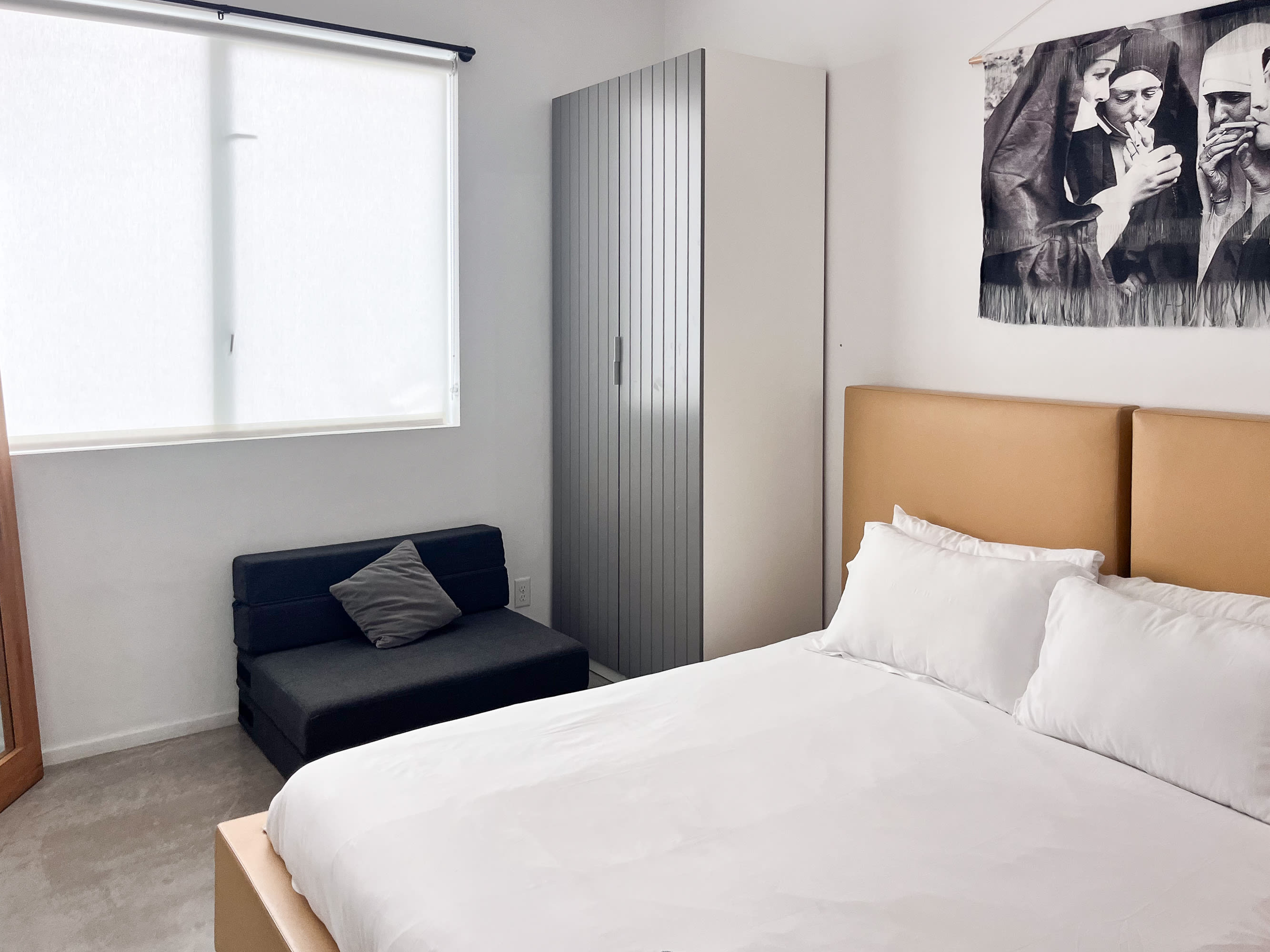 Minimalist Bedroom With A Queen Bed, Unique Art, And Modern Lighting