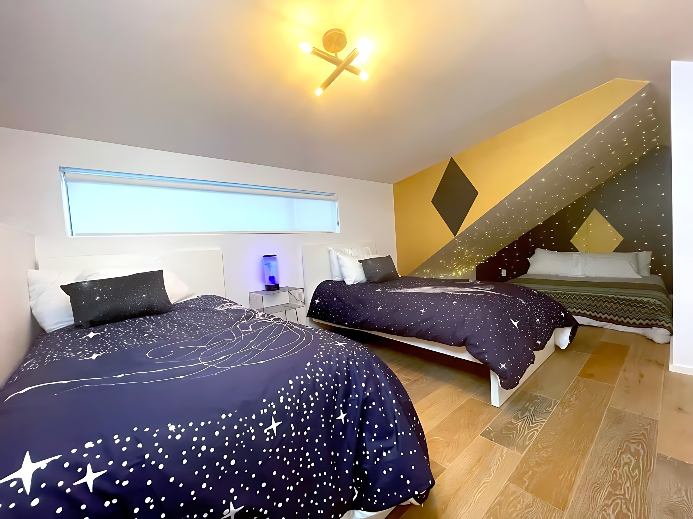 Cosmic-Themed Bedroom With Two Queen Beds And Unique Wall Design