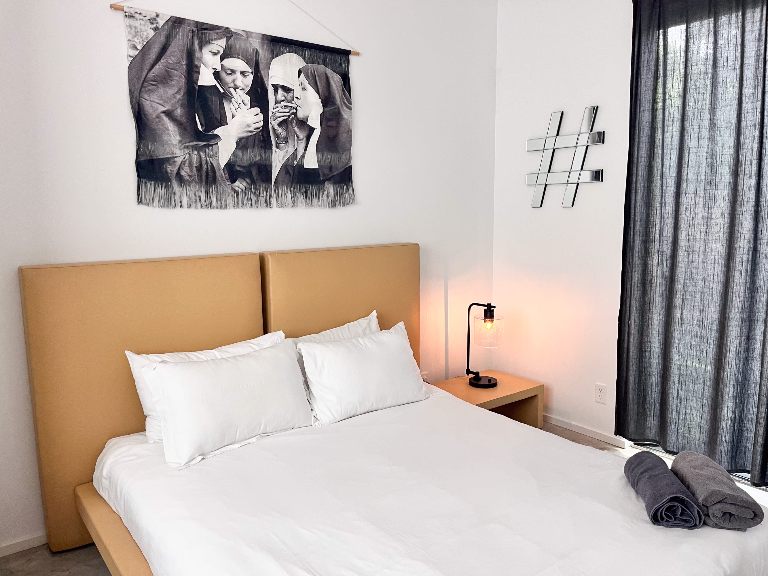 Minimalist Bedroom With A Queen Bed, Unique Art, And Modern Lighting